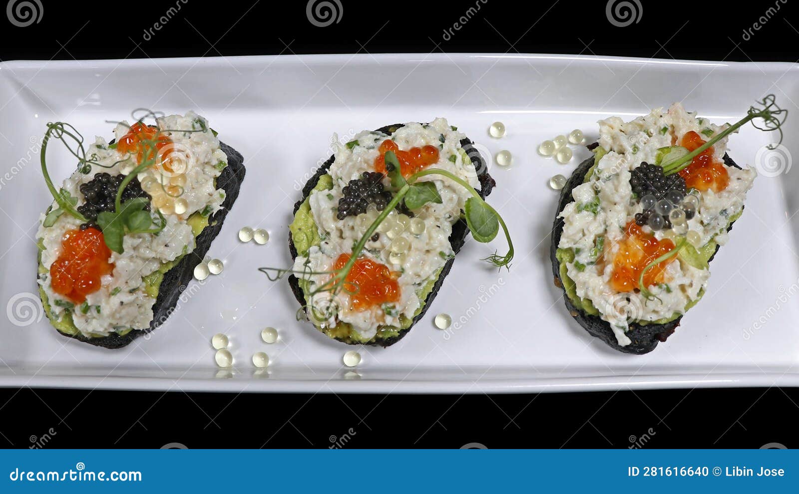 Crab Caviar Tart with Avocado Spread and Charcoal Toast Stock Photo