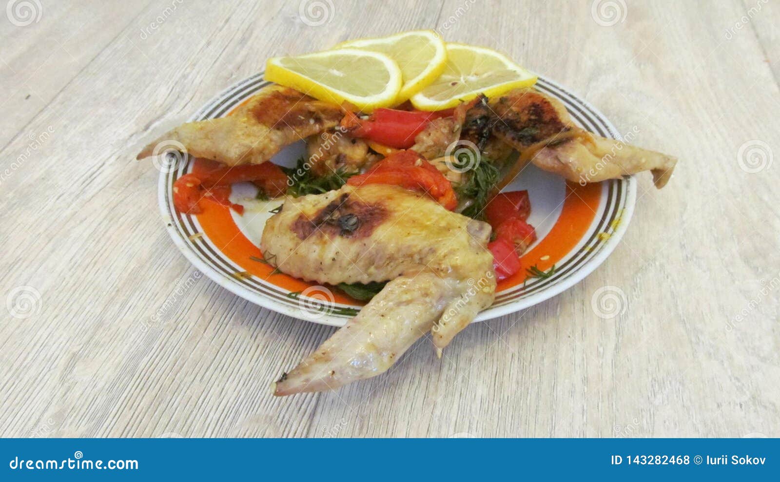 Куриные ÐºÑ€Ñ‹Ð»ÑŒÑ Ñ Ð¶Ð°Ñ€ÐµÐ½Ñ‹Ð¼ перцем и дольками лимона Stock