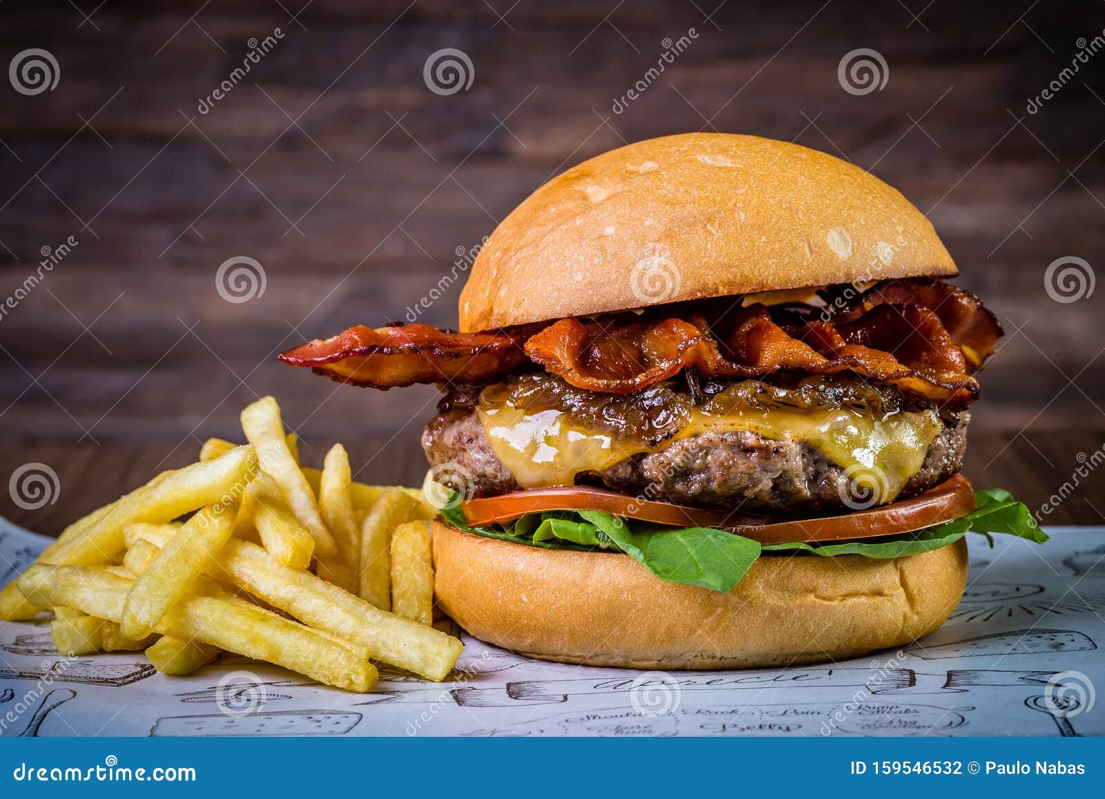 craft beef burger with cheese, bacon, rocket leafs, caramelize onion and french fries on wood table and rustic background