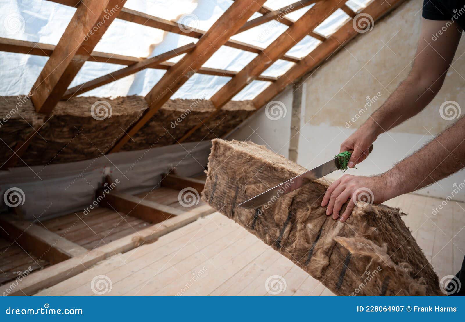 craftsman cutting insulation material to insulate the attic