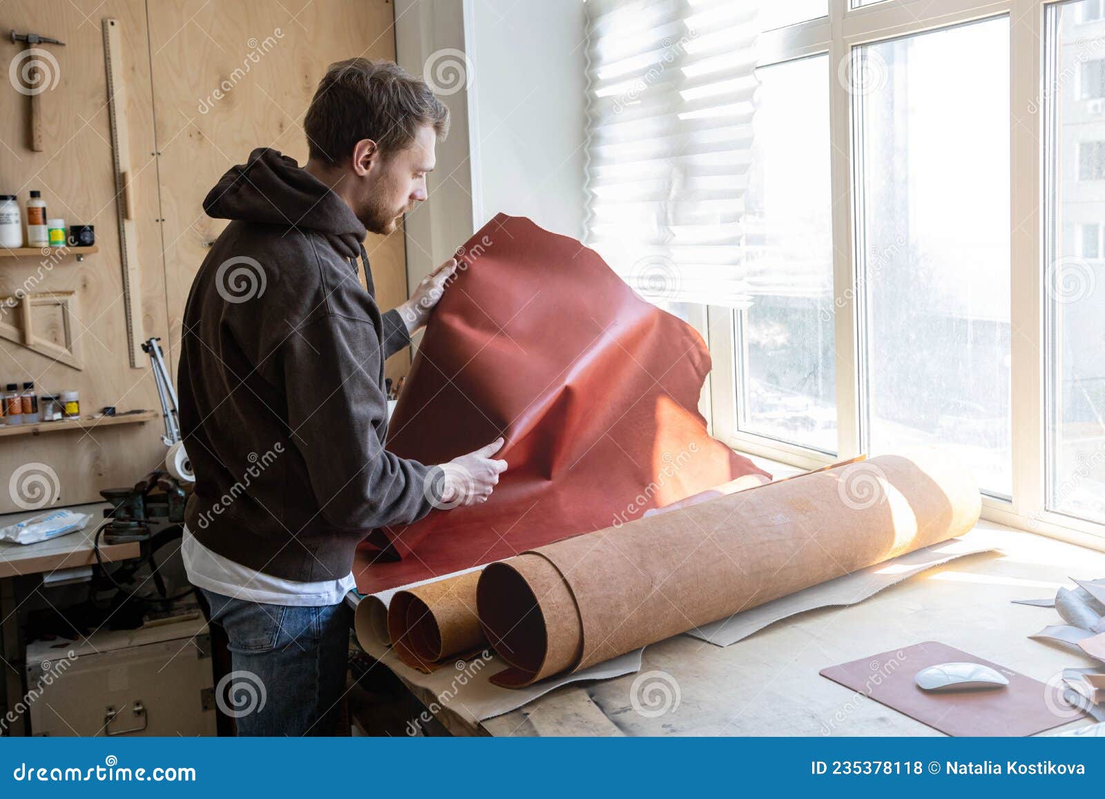 craftsman unwrapping bundle of stuff natural material working at leather workshop. leatherwork