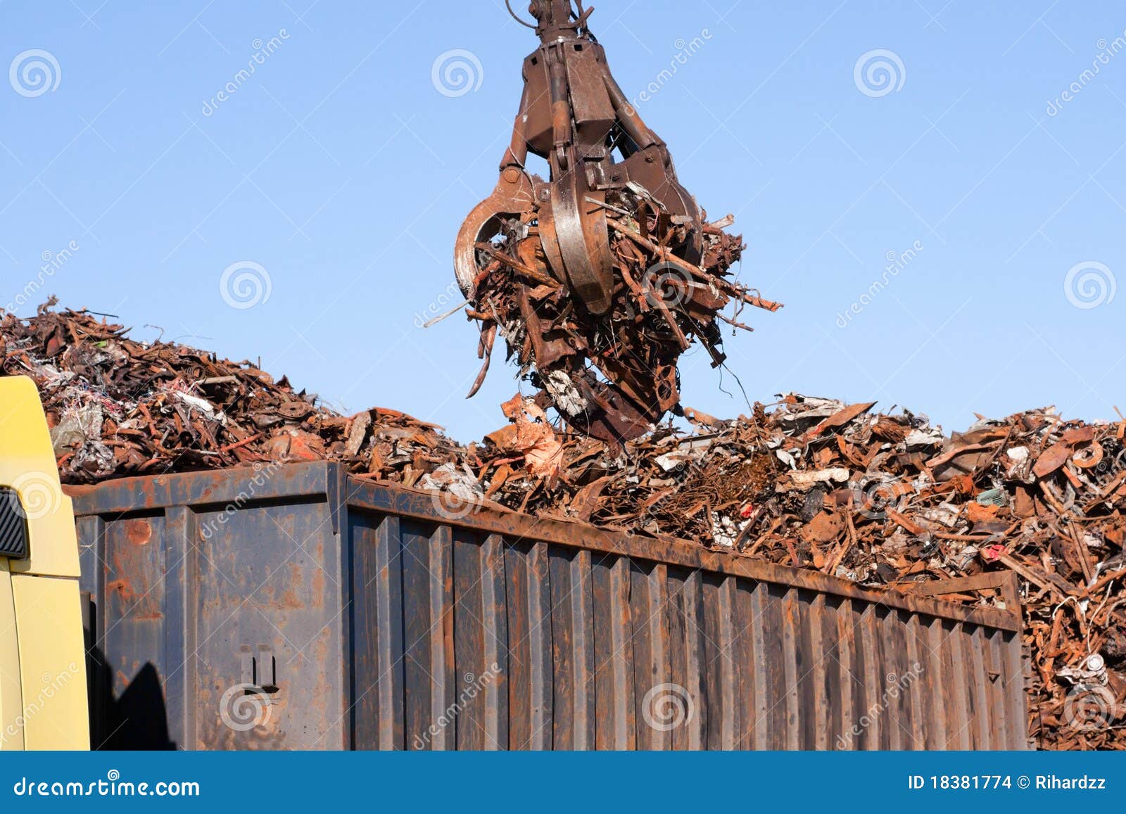 crane grabber loading a truck with metal scrap