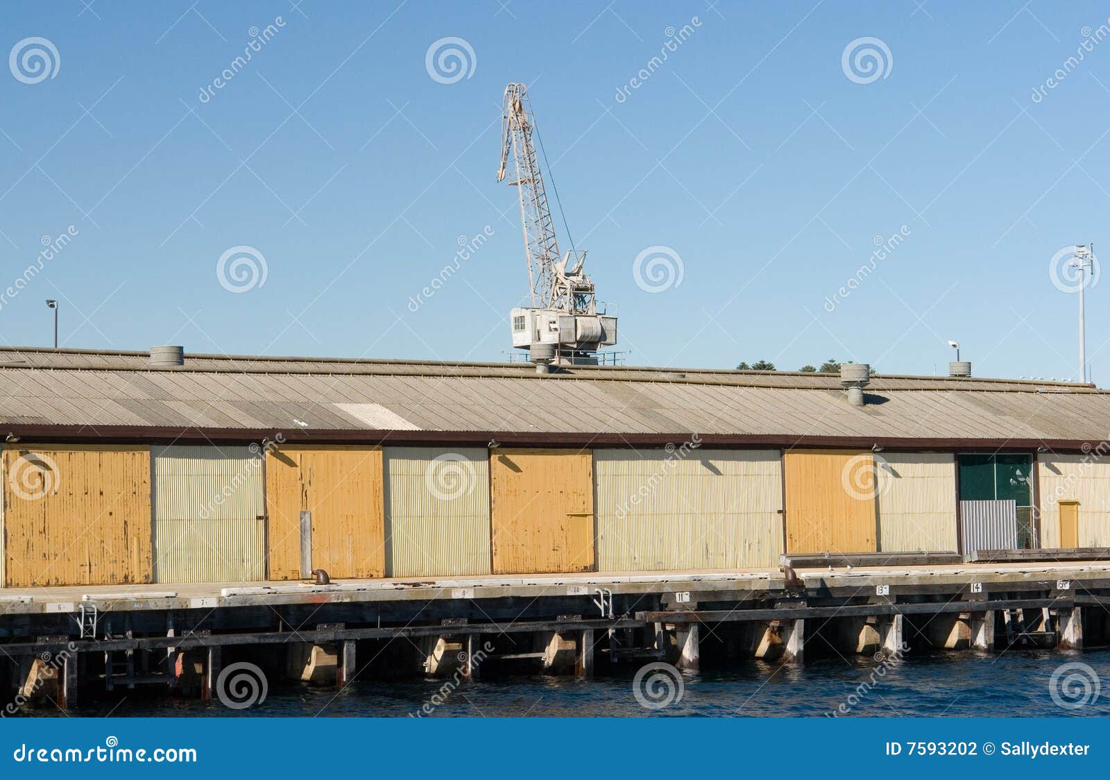 Crane on wharf cargo sheds stock photo. Image of harbour 7593202