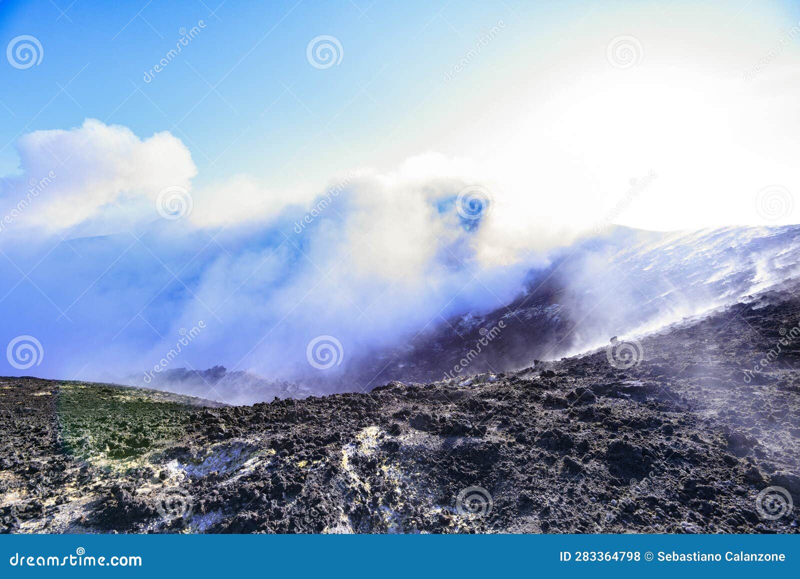 cratere etna - vista panoramica durante giornata di sole con emissione di vapore e gas
