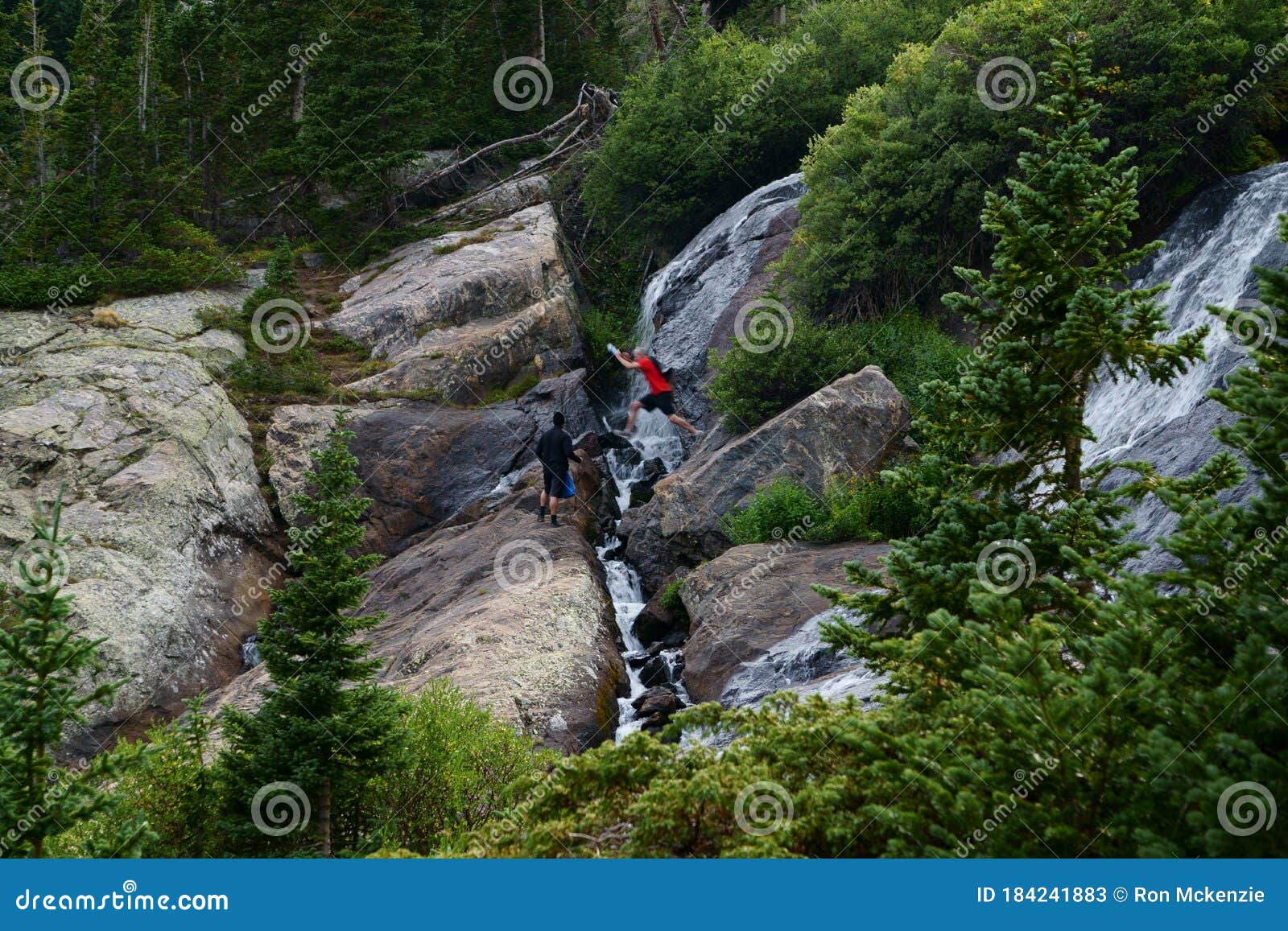 crazy man jumping over a mountain stream