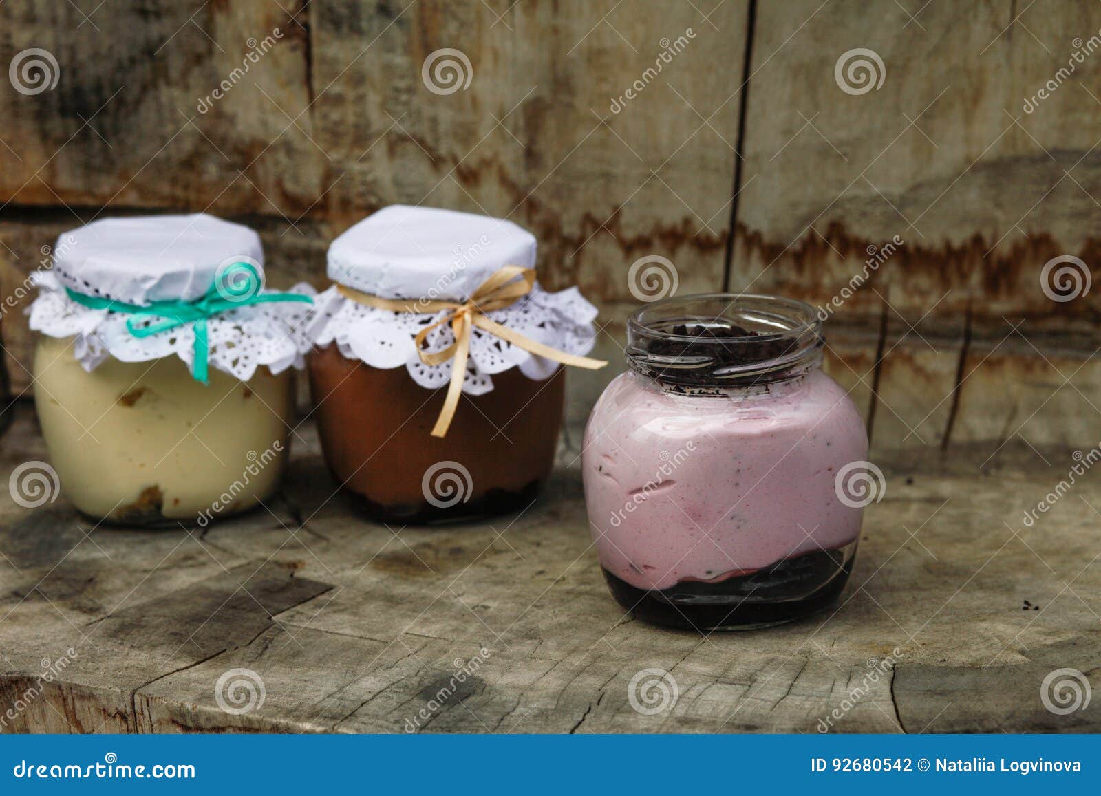 Creamy Dessert In A Small Glass Jars With Ribbon On A Wooden