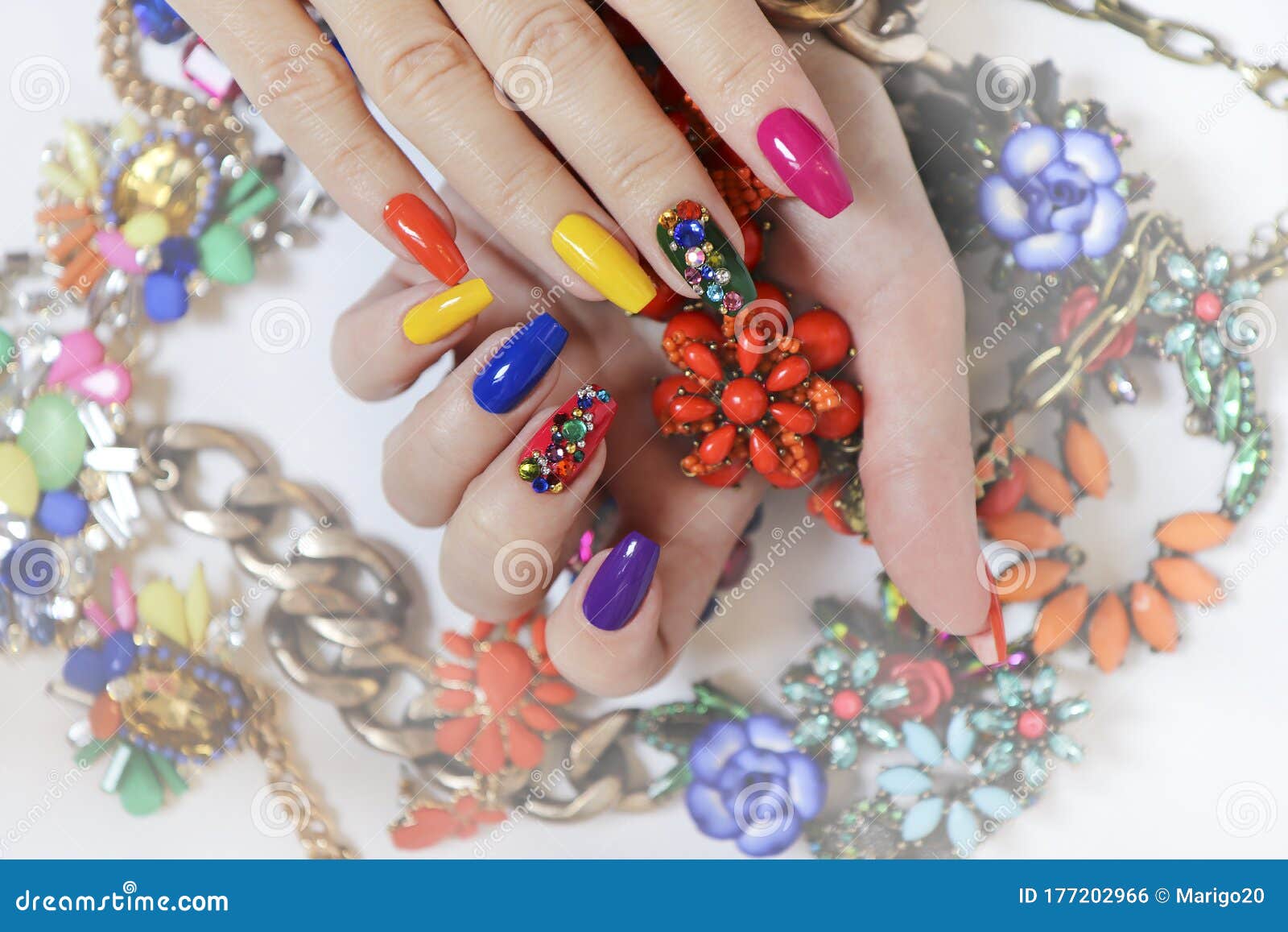 creative bright saturated manicure on long nails with rhinestones.