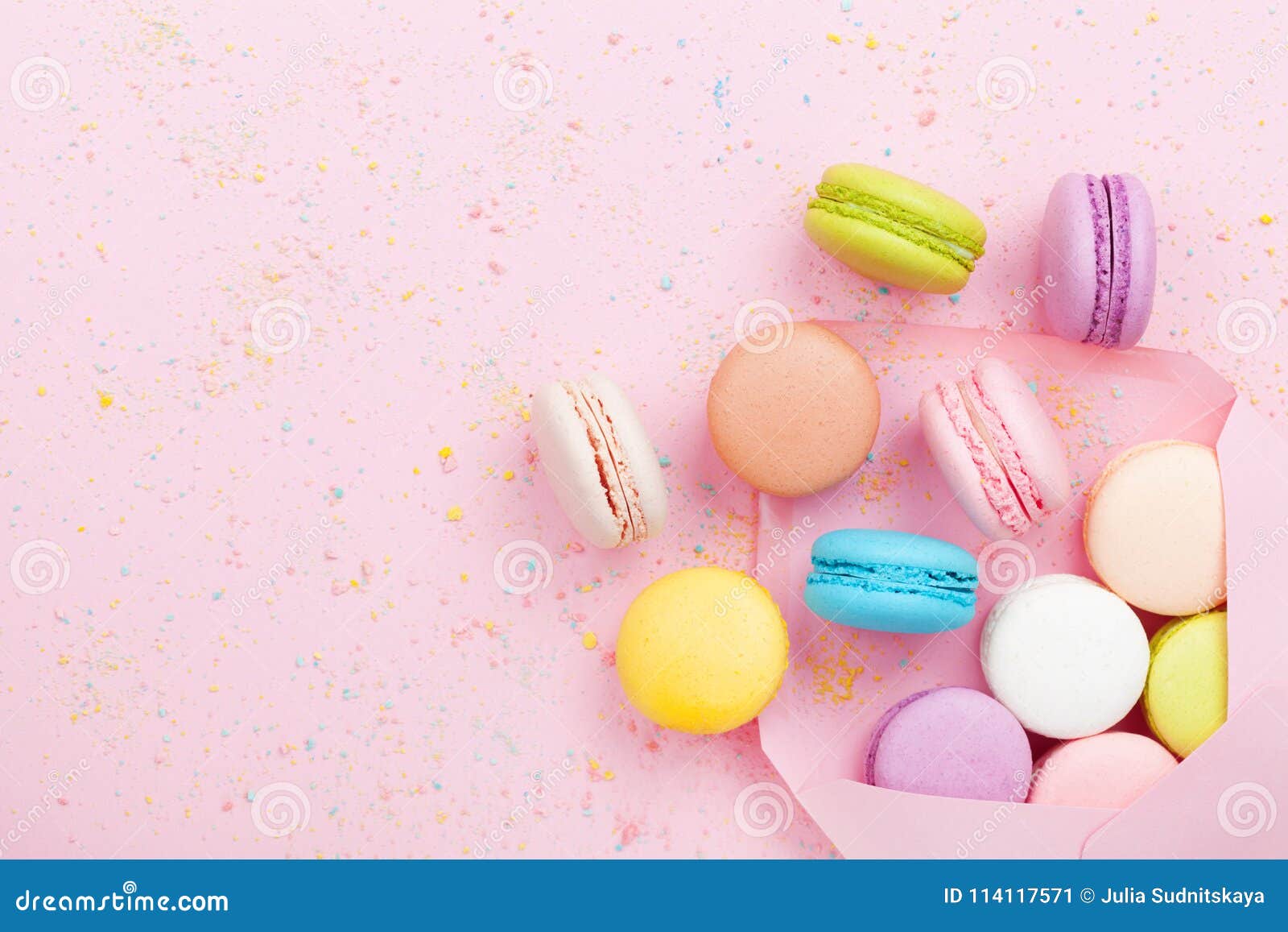 creative composition with envelope and cake macaron or macaroon on pink pastel background top view. flat lay.