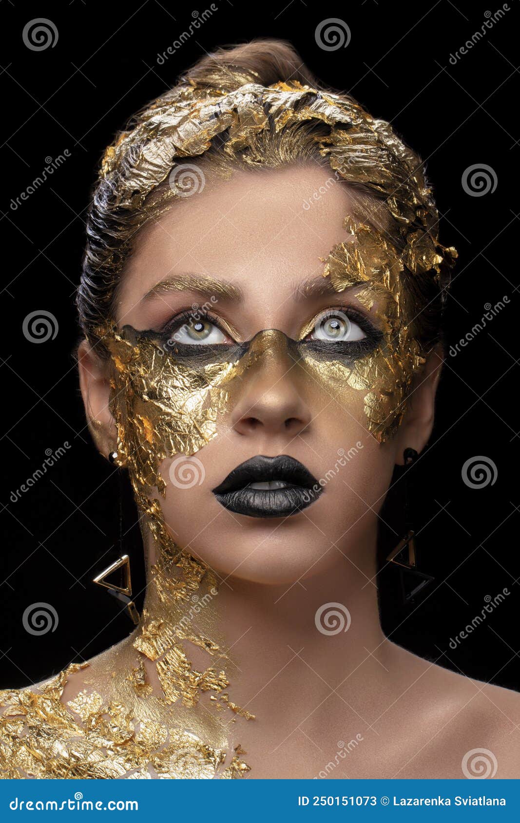 A beautiful young woman with golden face paint and glitter