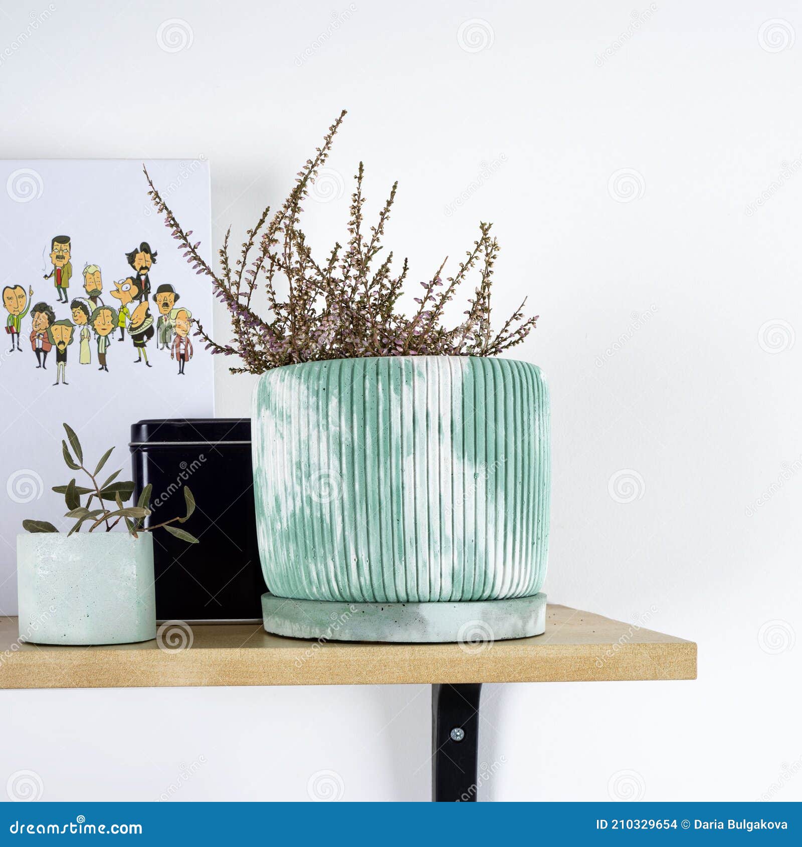creative narural homemade flowerpot in green concrete with dried flowers on a shelf in a cozy home. wabi sabi, eco green