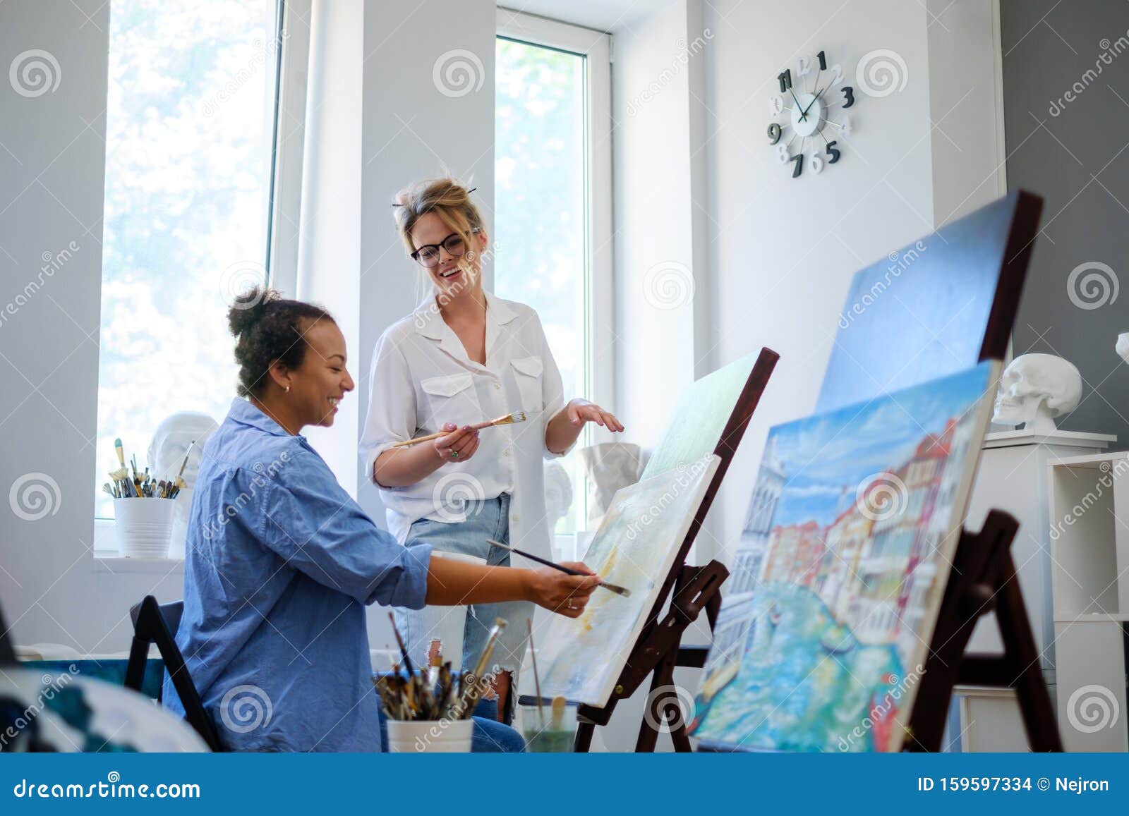 creative painter and her protege working in a studio