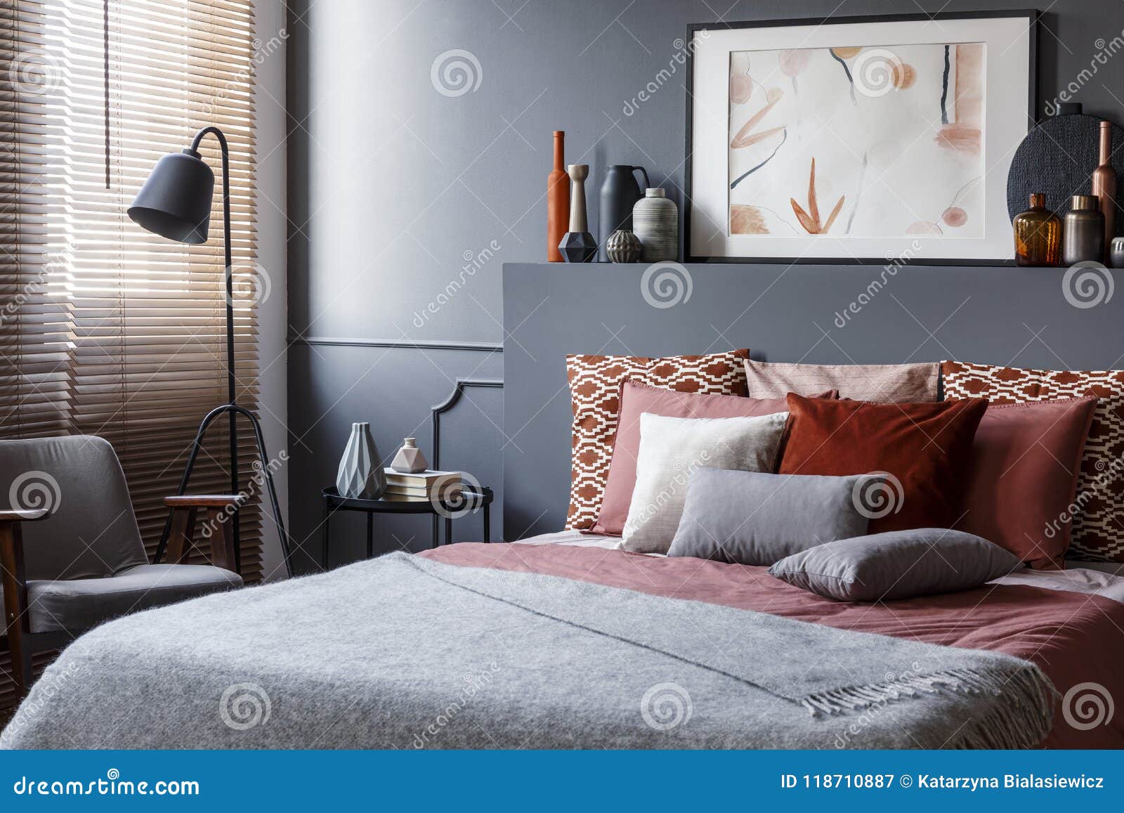creative poster on black bedhead above cozy bed with decorative