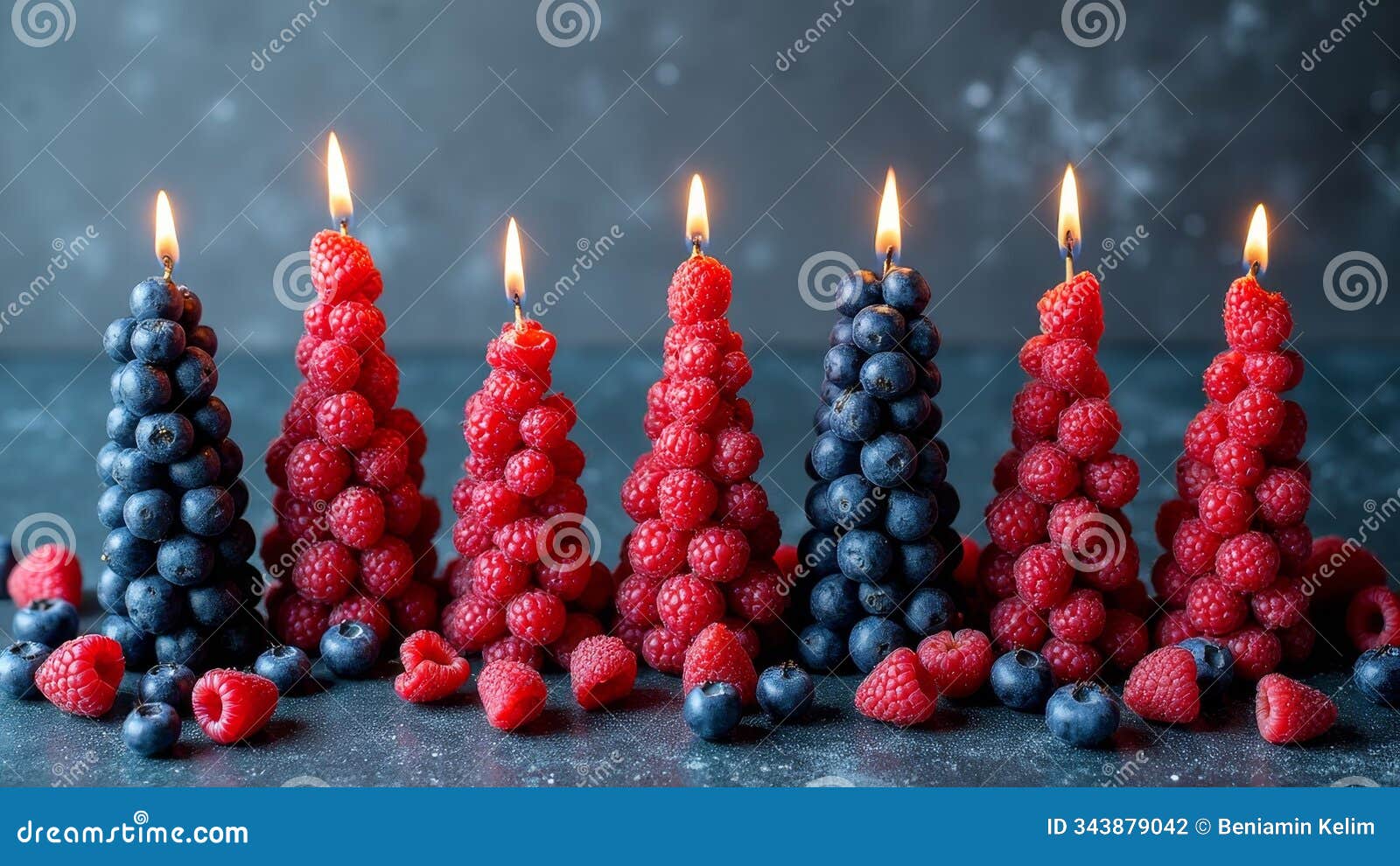 creative raspberry and blueberry candle arrangement against dark background