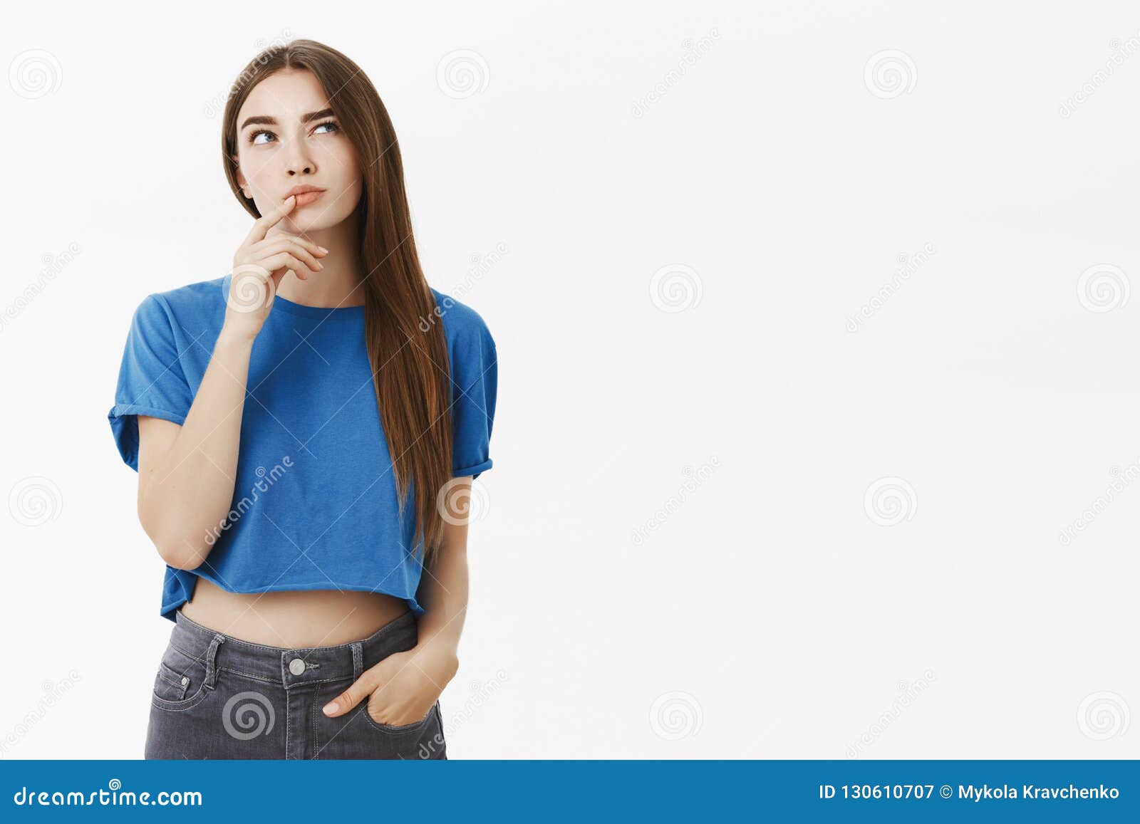 creative smart and thoughtful attractive european woman in trendy blue cropped top making hmm gesture with finger on