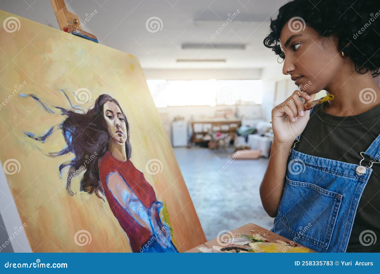 Creative Woman Thinking about Her Art and Looks at Painting in Studio Creative Woman Thinking about Her Art and Looks at Painting in Studio