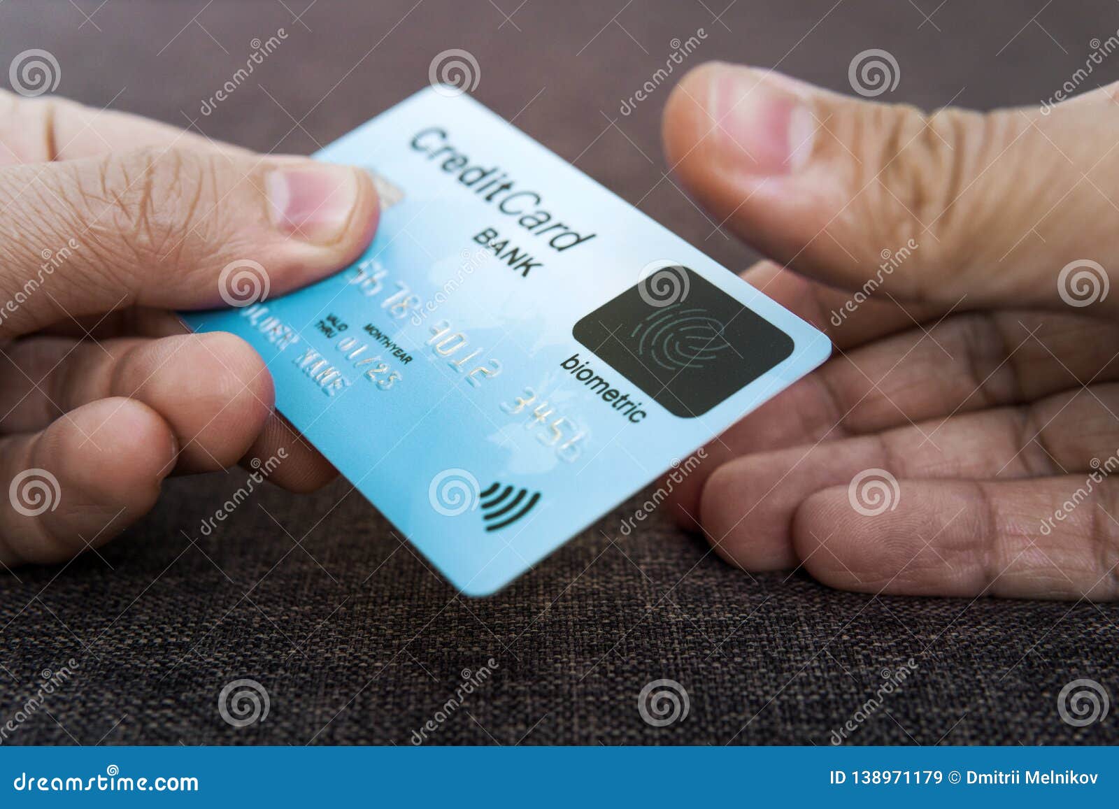 credit card has built-in fingerprint scanner.  of biometric payment security. one male hand is holding blue card and