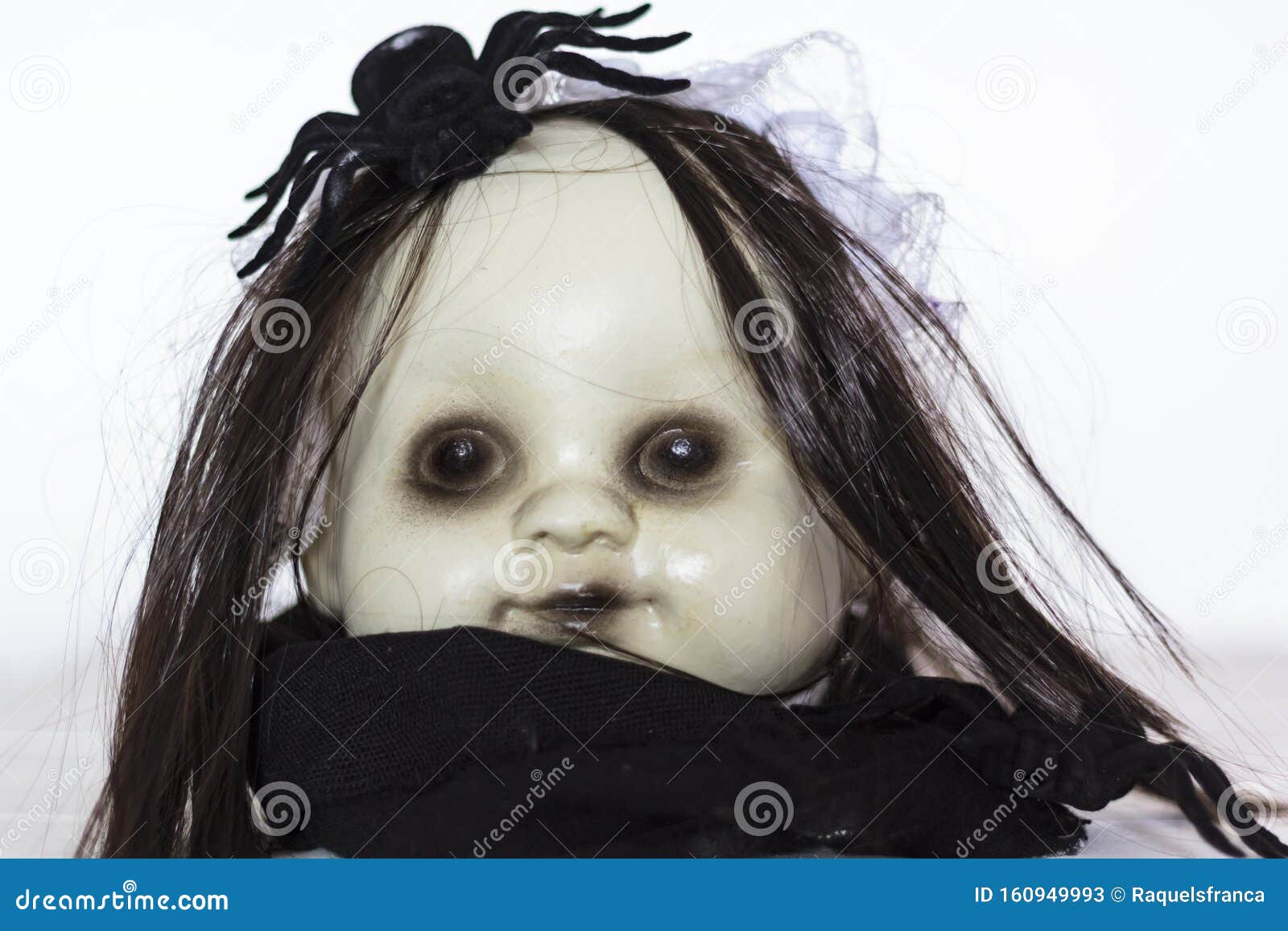 A high angle of a creepy old doll with disheveled hair sitting in the  garden Stock Photo - Alamy
