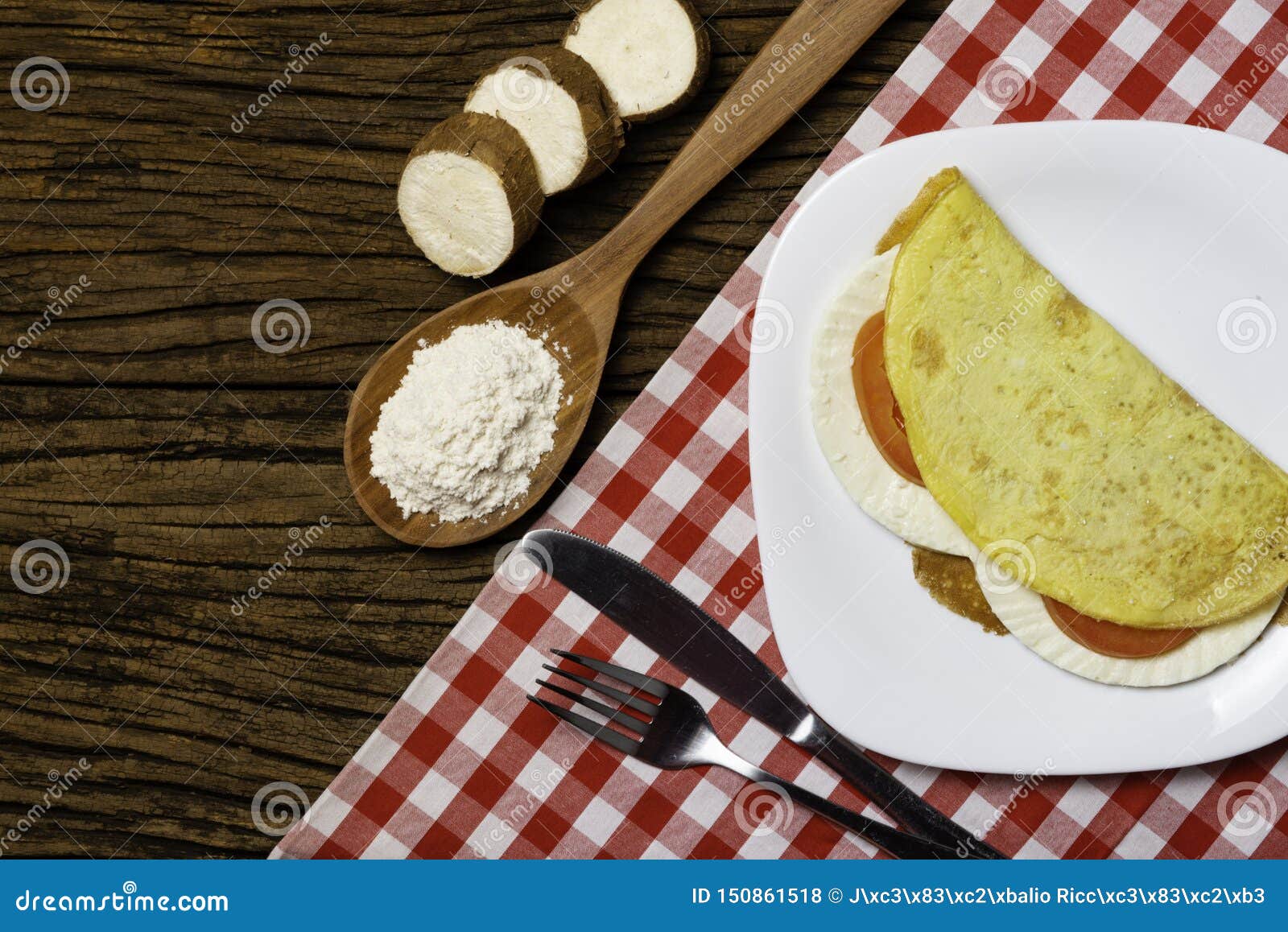 crepioca. pancake of cassava tapioca with cheese and tomato on plate on old wooden background. selective focus