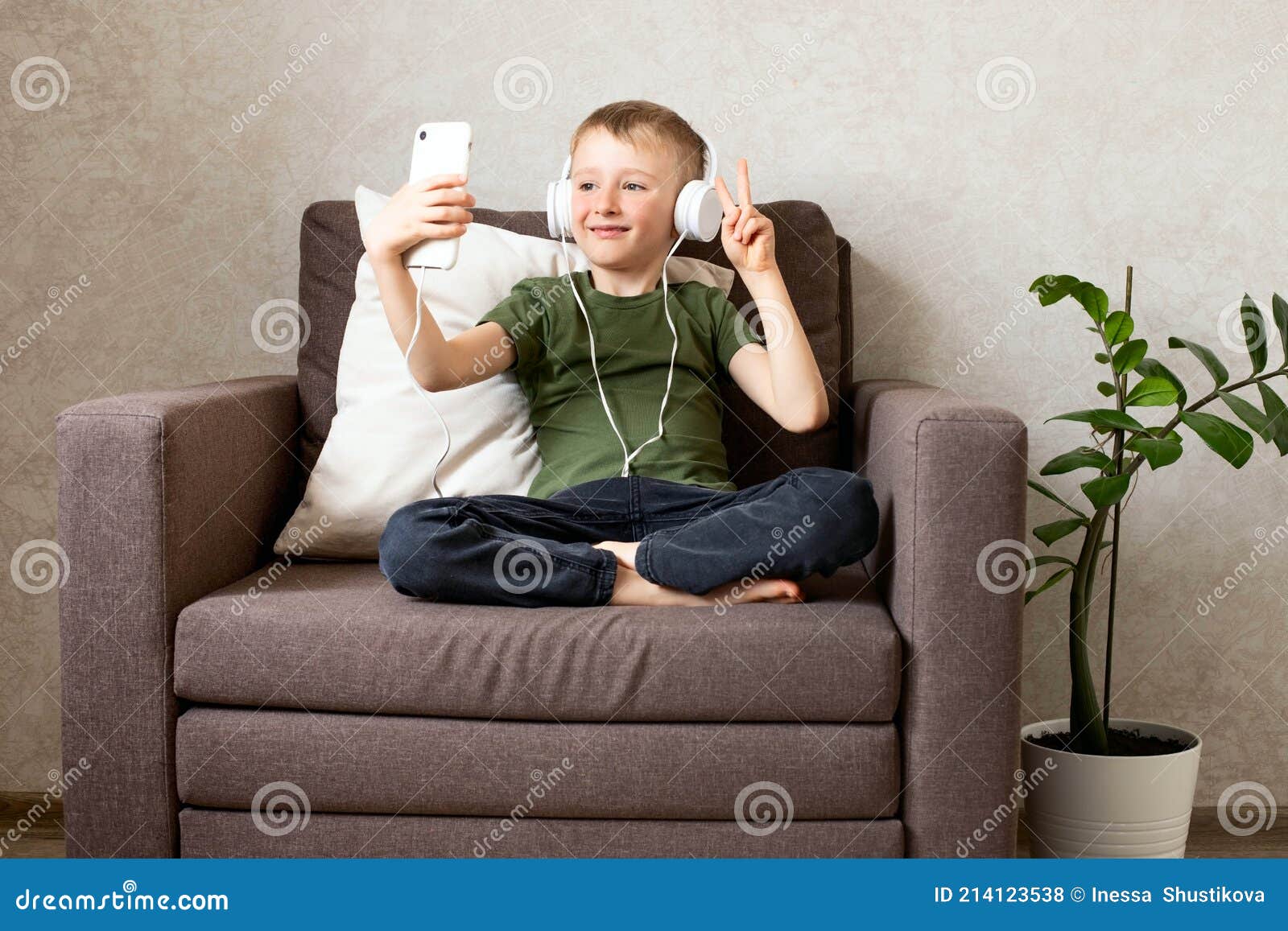 Um menino com fones de ouvido está sentado em um computador