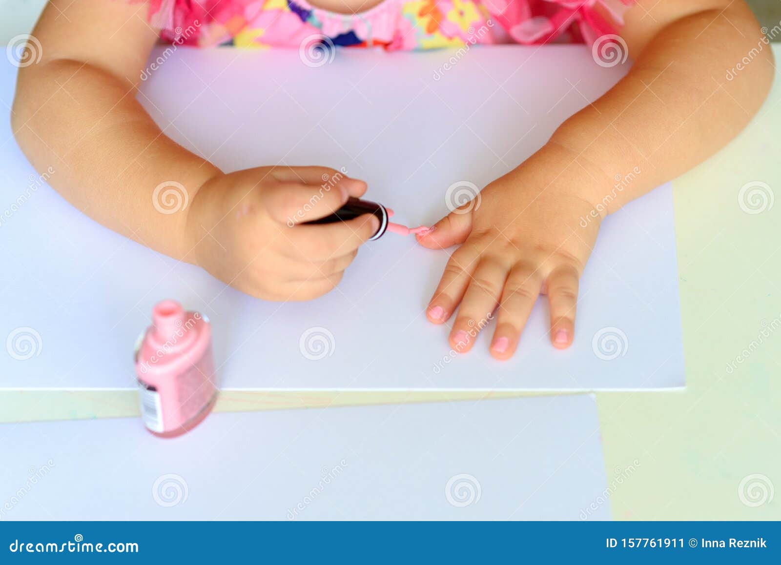 Criança Bonitinha, De Cor Rosa Elegante, Sentada à Mesa Branca De Madeira E  Fazendo Manicura Imagem de Stock - Imagem de independente, escova: 157761911