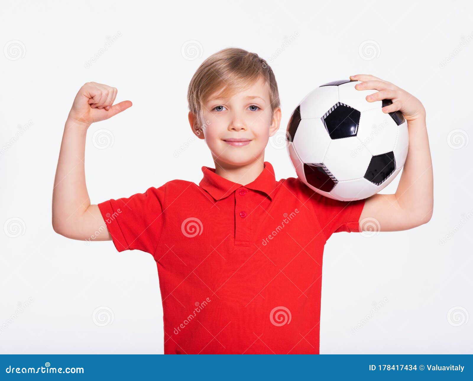 Um garoto segurando a velha bola de futebol antes de começar um jogo de  futebol