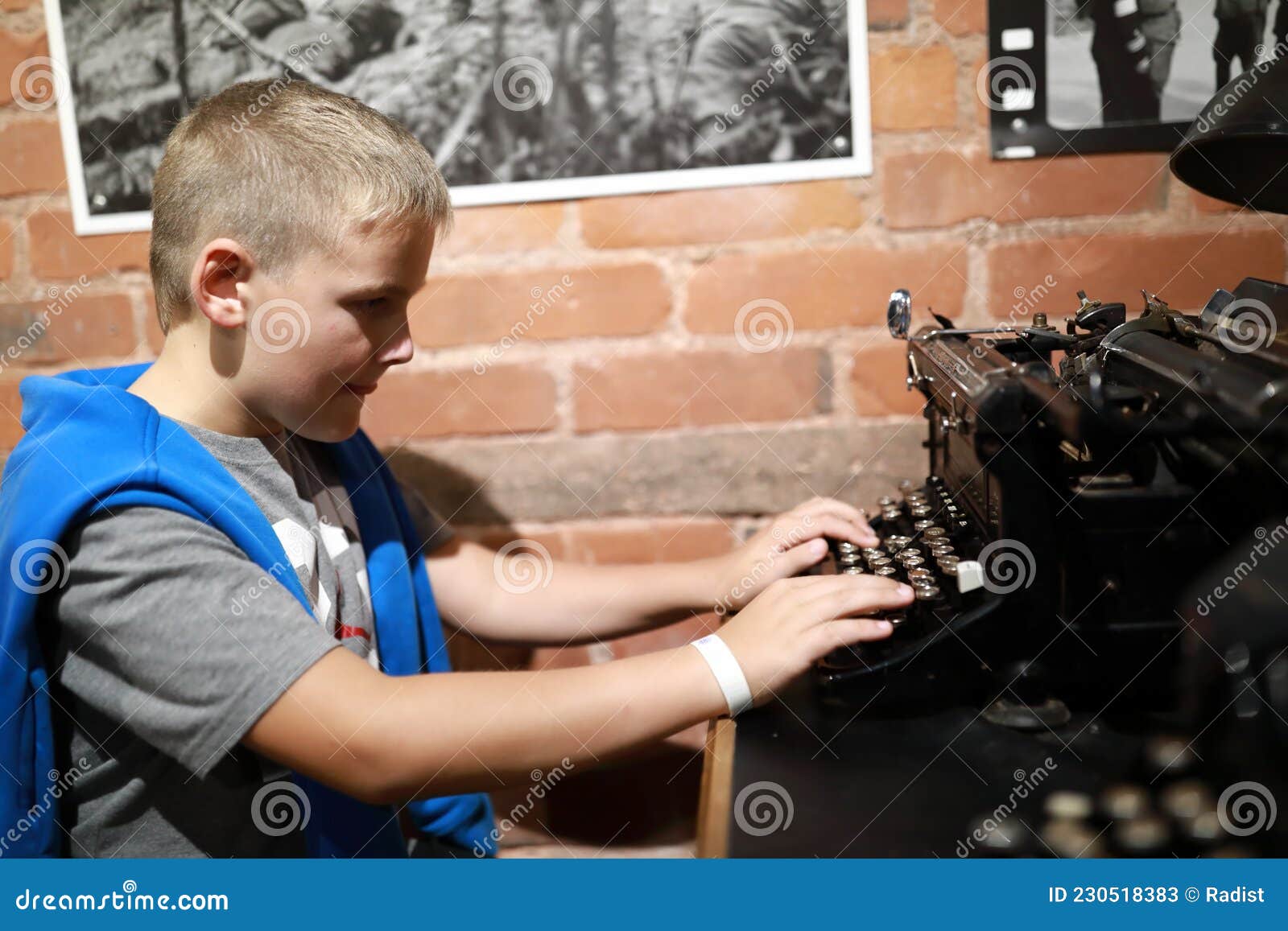 Um menino está jogando uma máquina de escrever em um fundo