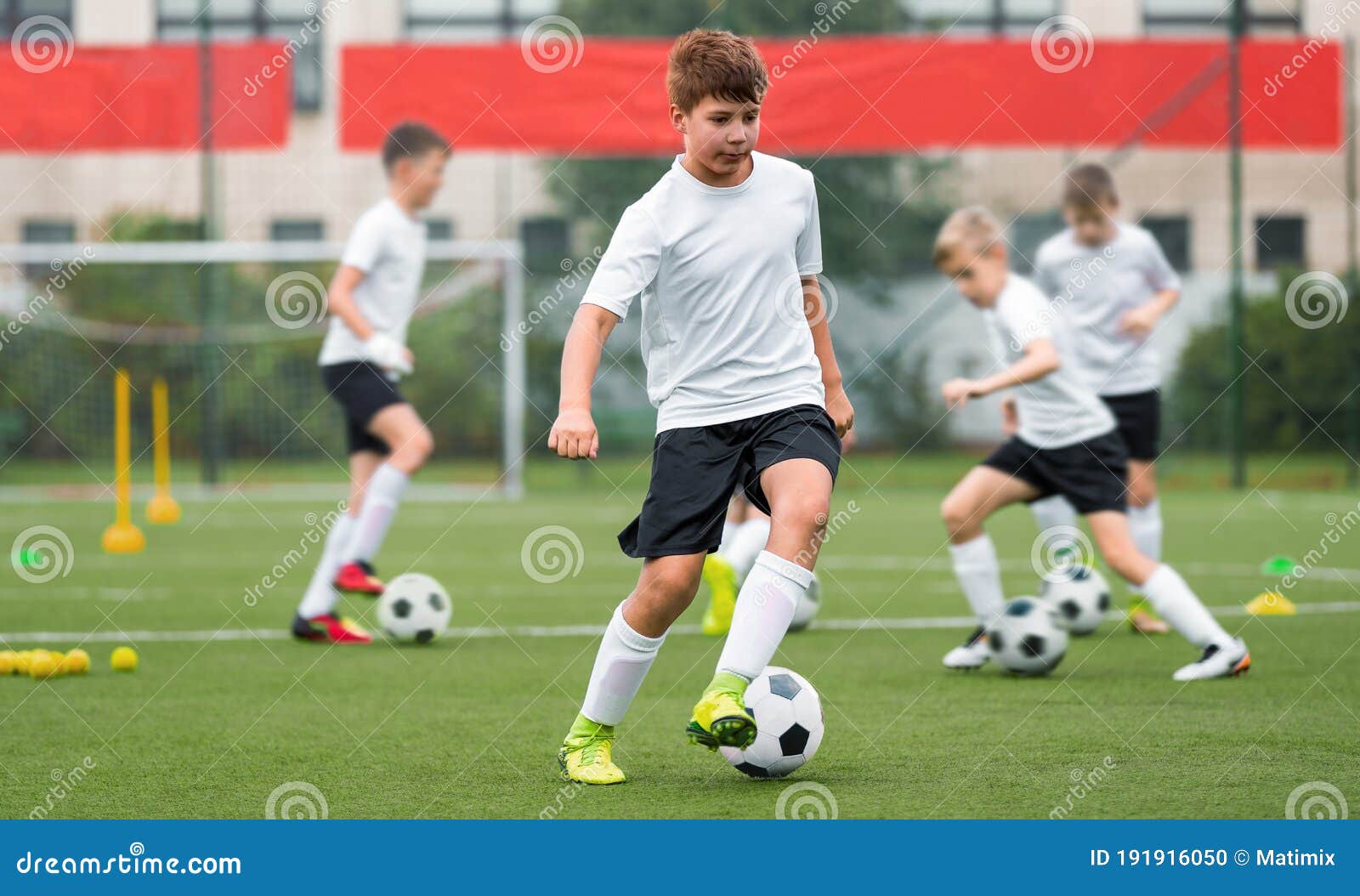 Grupo De Meninos Em Duas Equipes De Futebol De Crianças Competindo Pela  Bola Em Uma Partida De Torneio De Futebol. Crianças Da Escola De Futebol  Que Jogam O Jogo No Campo De