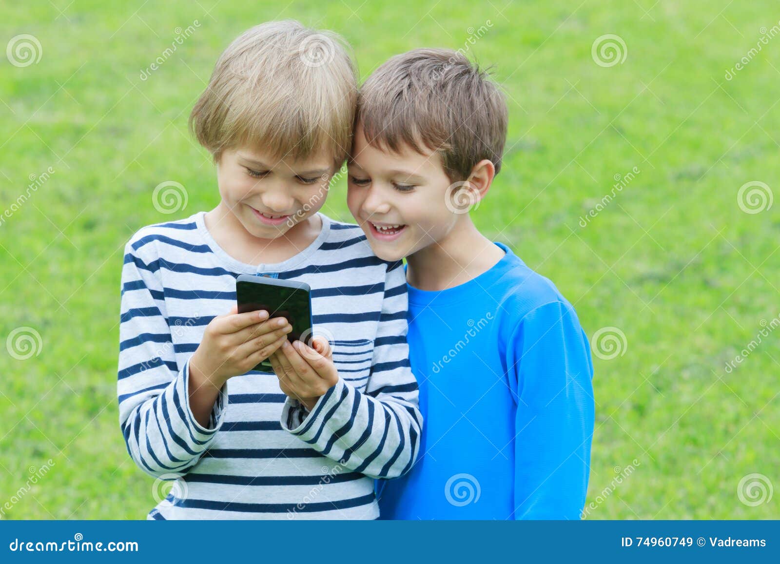 Crianças Com O Telefone Celular Exterior Dois Meninos Que Sorriem