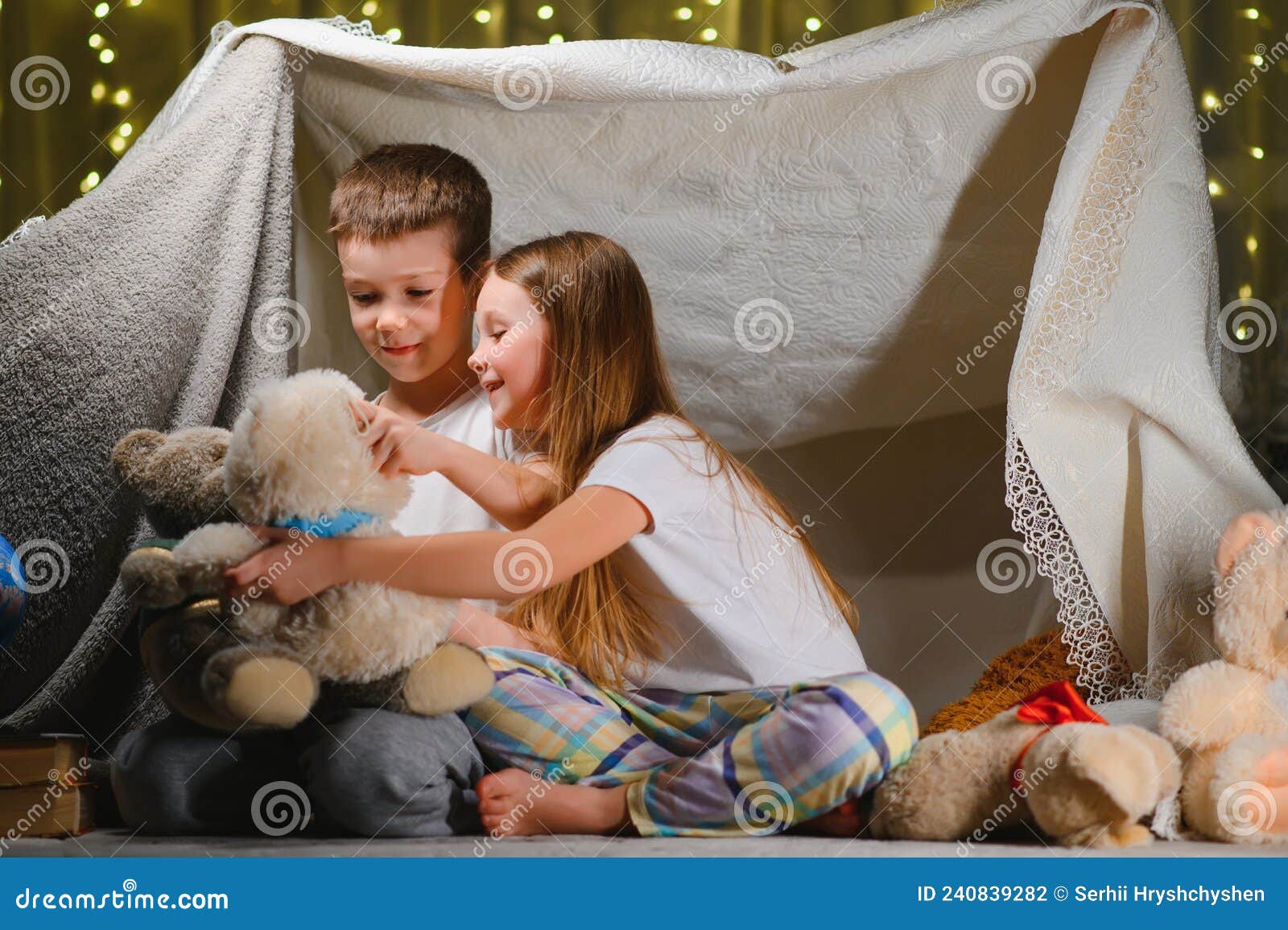 Quarto de criança com tenda e jogo de brincar com ursinho no chão.