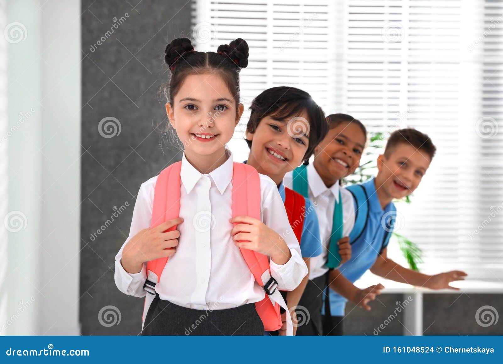 Crianças Felizes De Uniforme Escolar Com Mochilas Foto de Stock - Imagem de  menino, recuo: 161048524, image size:1600x1157