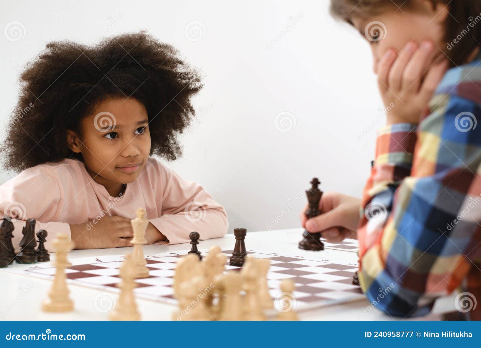 Criança jogando xadrez na aula de escola menino jogando jogo de