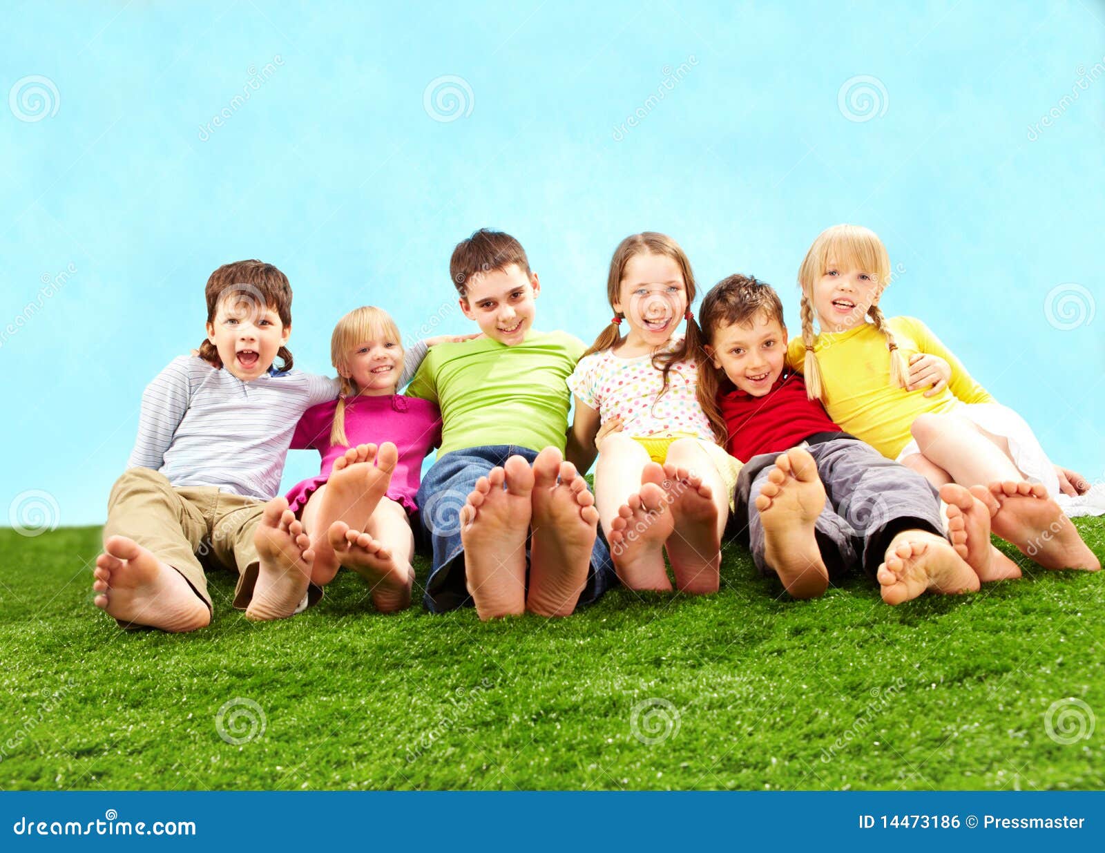 Crianças de relaxamento. Grupo de crianças felizes que relaxam na grama junto