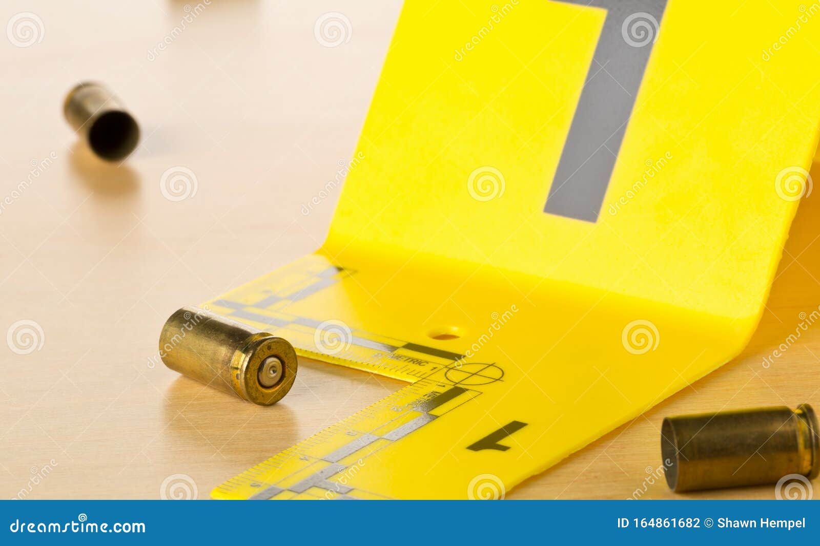 crime scene investigation csi evidence marker with empty, fired 9mm bullet casings on wood floor background at crime scene -