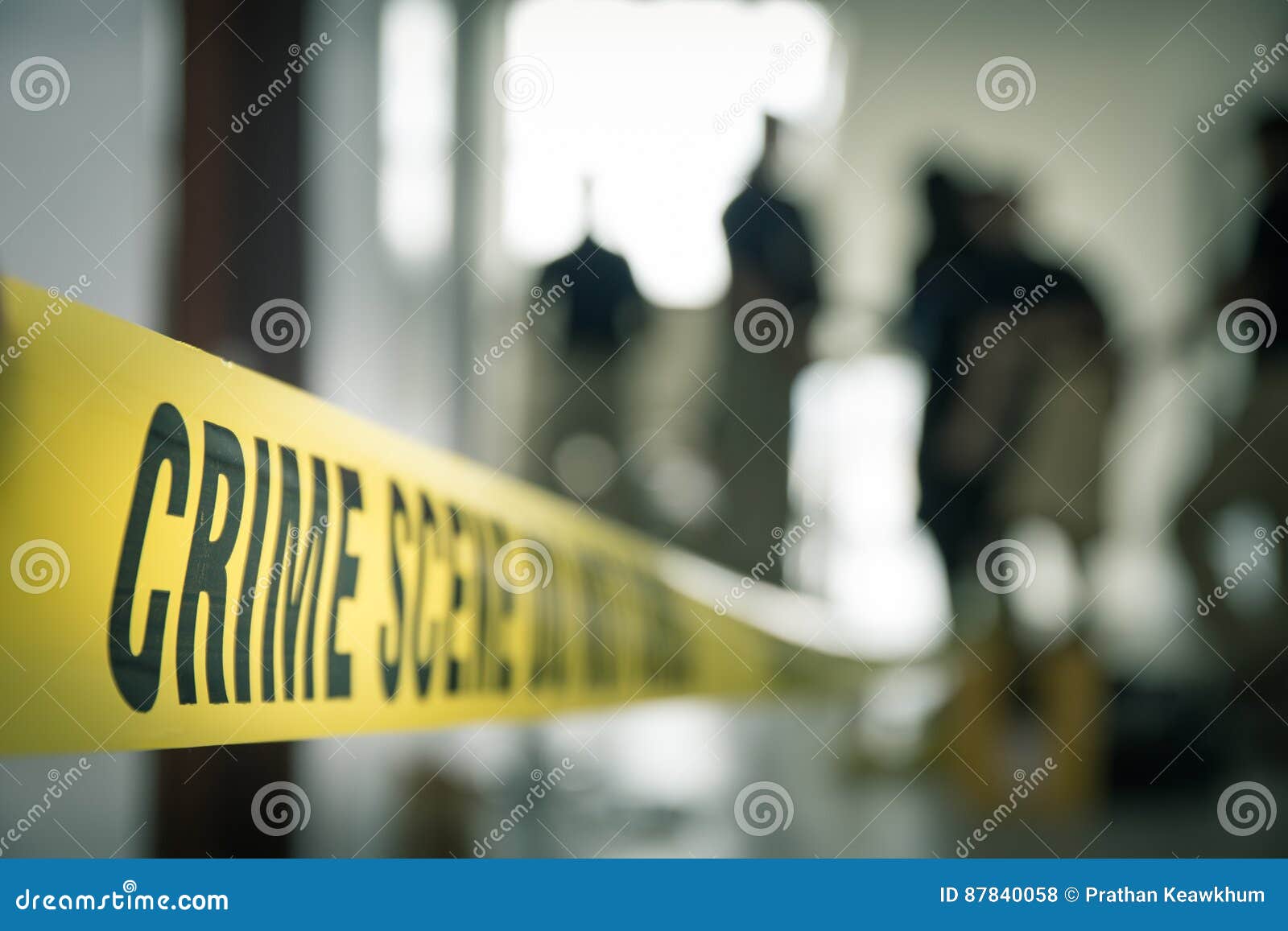 crime scene tape with blurred forensic law enforcement background in cinematic tone