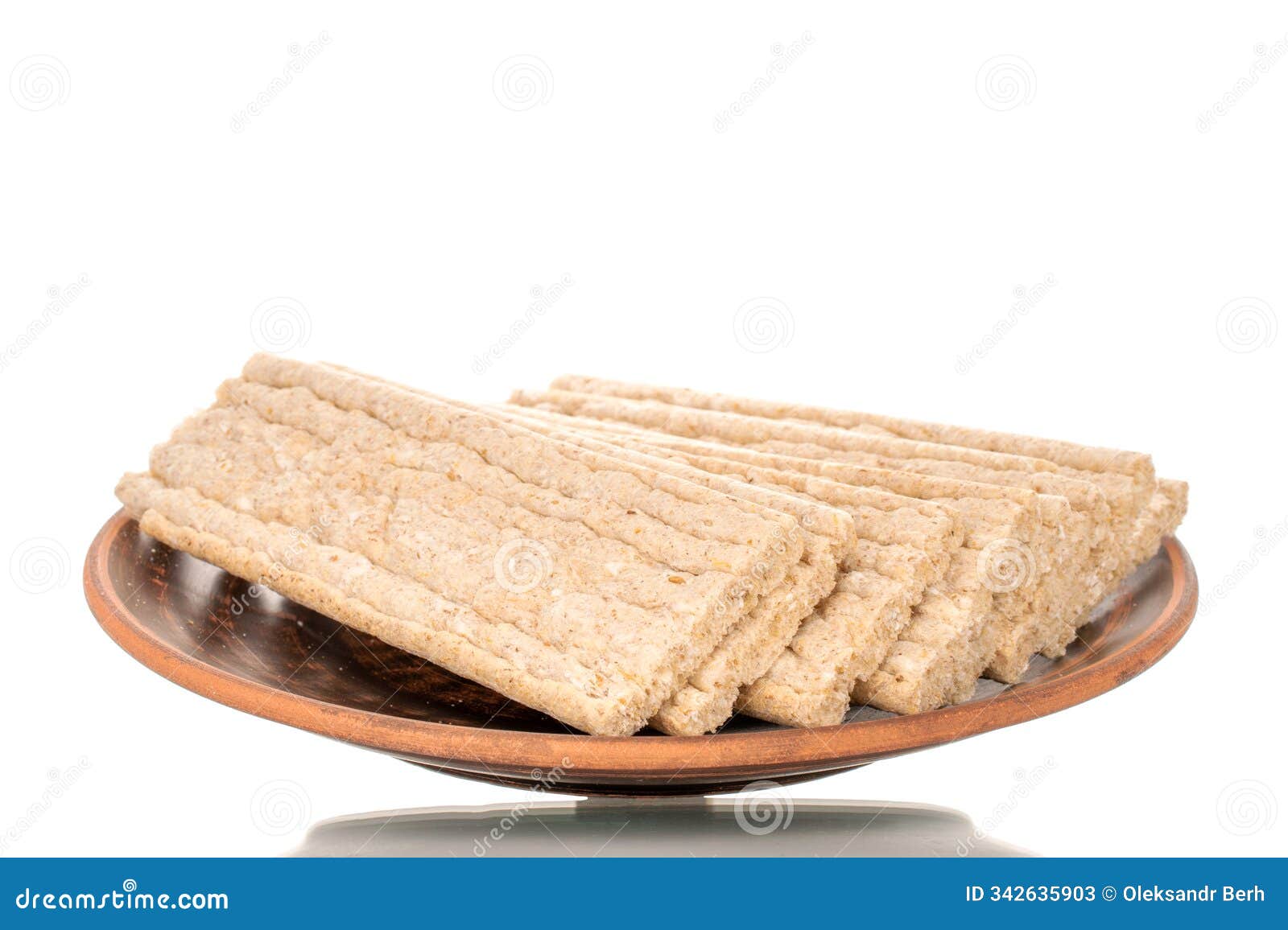 light brown multi-grain rye crispbread on a wooden table. crispy tasty crackers with ceramic dishes, macro,  on white back