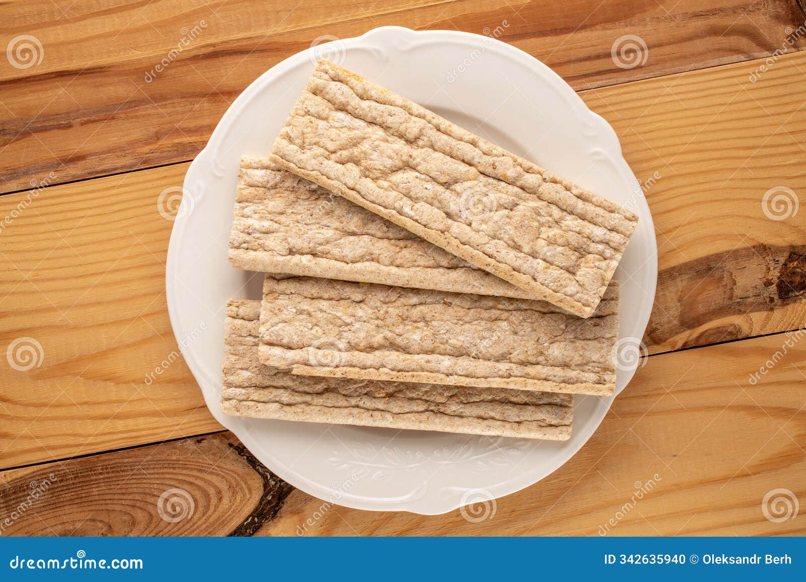 light brown multi-grain rye crispbread on a wooden table. crispy tasty crackers with ceramic dishes, macro,  on white back