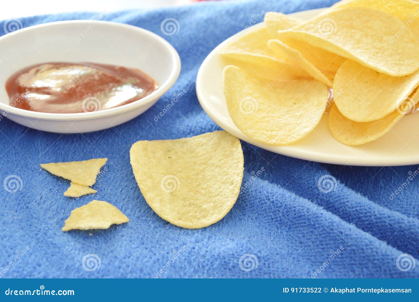 Crispy and Salt Potato Chips on Dish Dipping with Ketchup Stock Photo