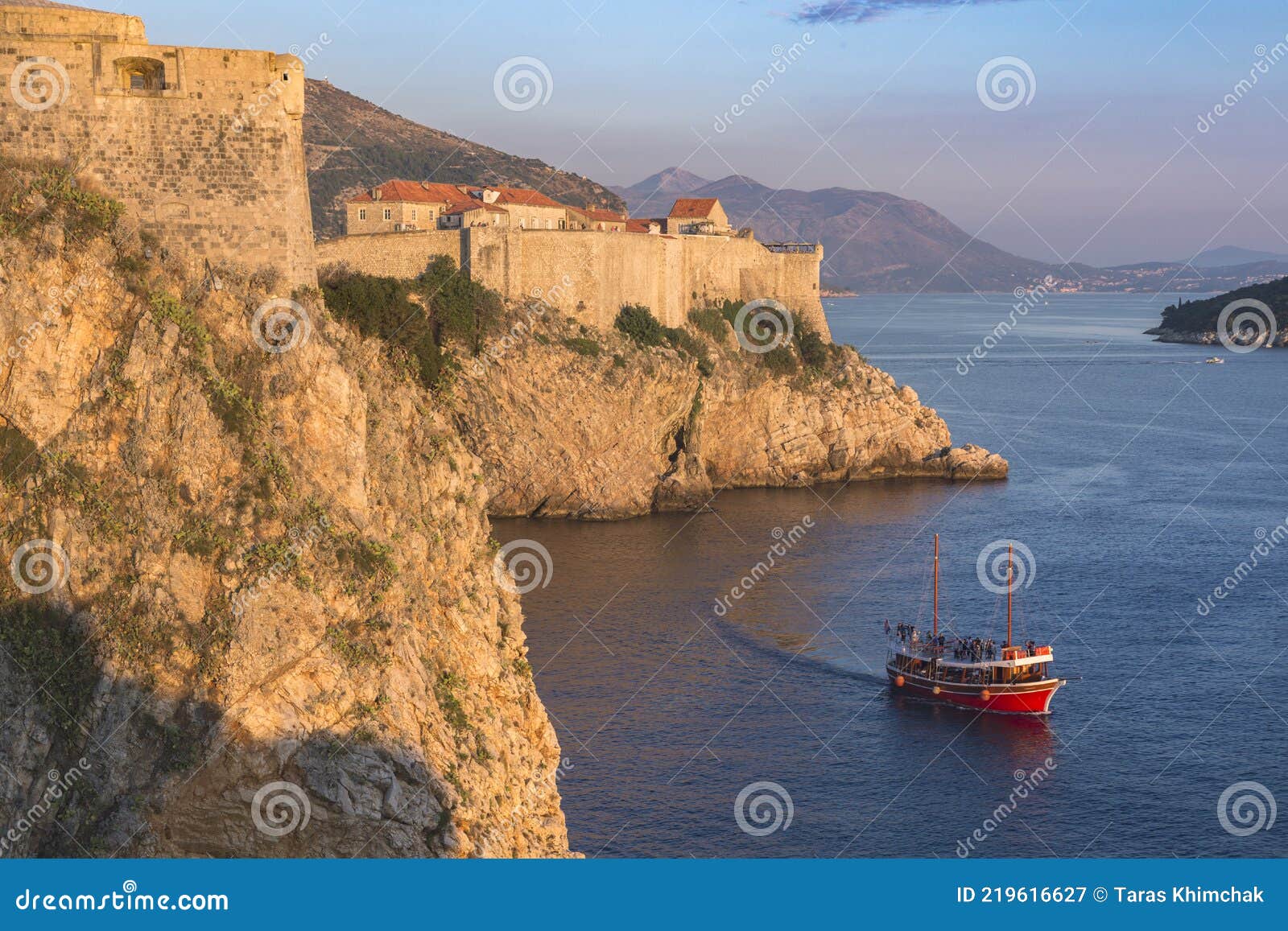 croatia. south dalmatia. aerial view of dubrovnik, medieval walled city and a read boat crossing the sea