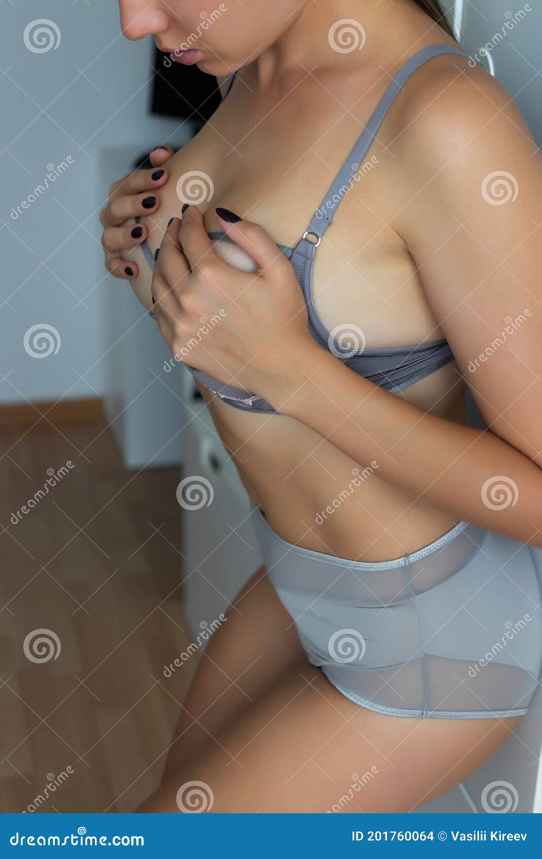 Nude woman holding bra Stock Photo - Alamy