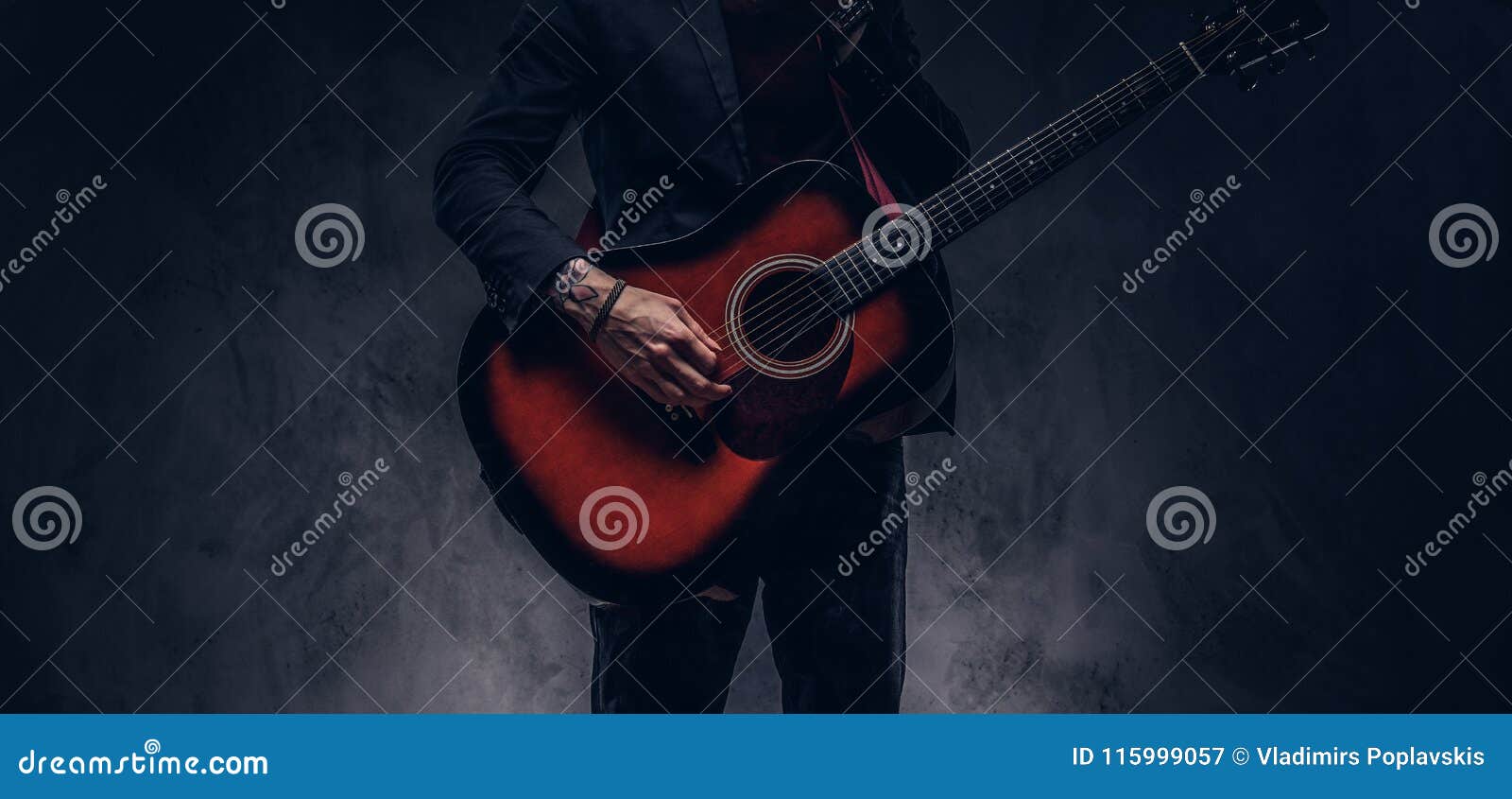 cropped image of a musician in elegant clothes with a guitar in his hands playing and posing.