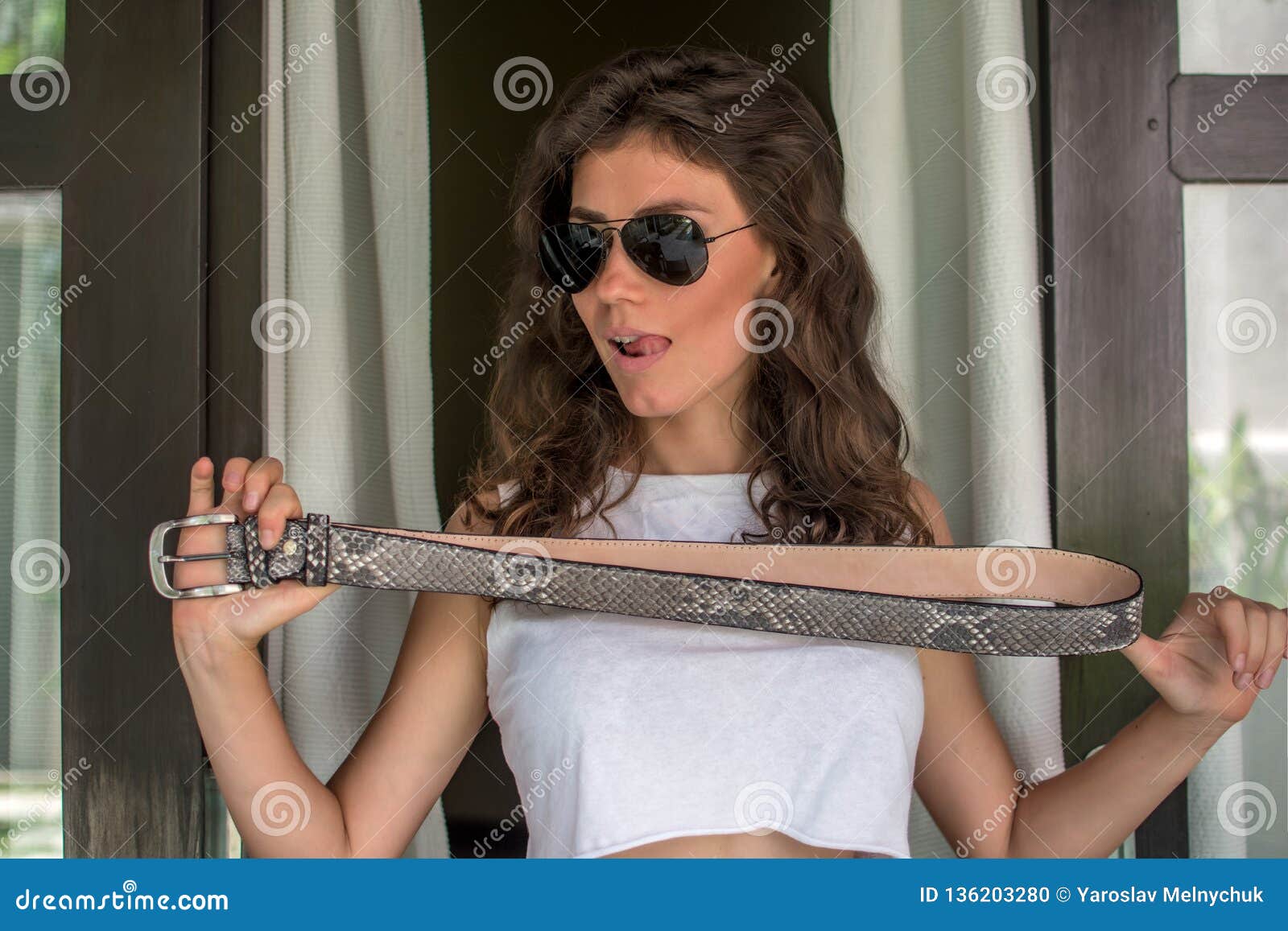 Cropped Image of Young Woman Holding Leather Python Belt. Free Empty