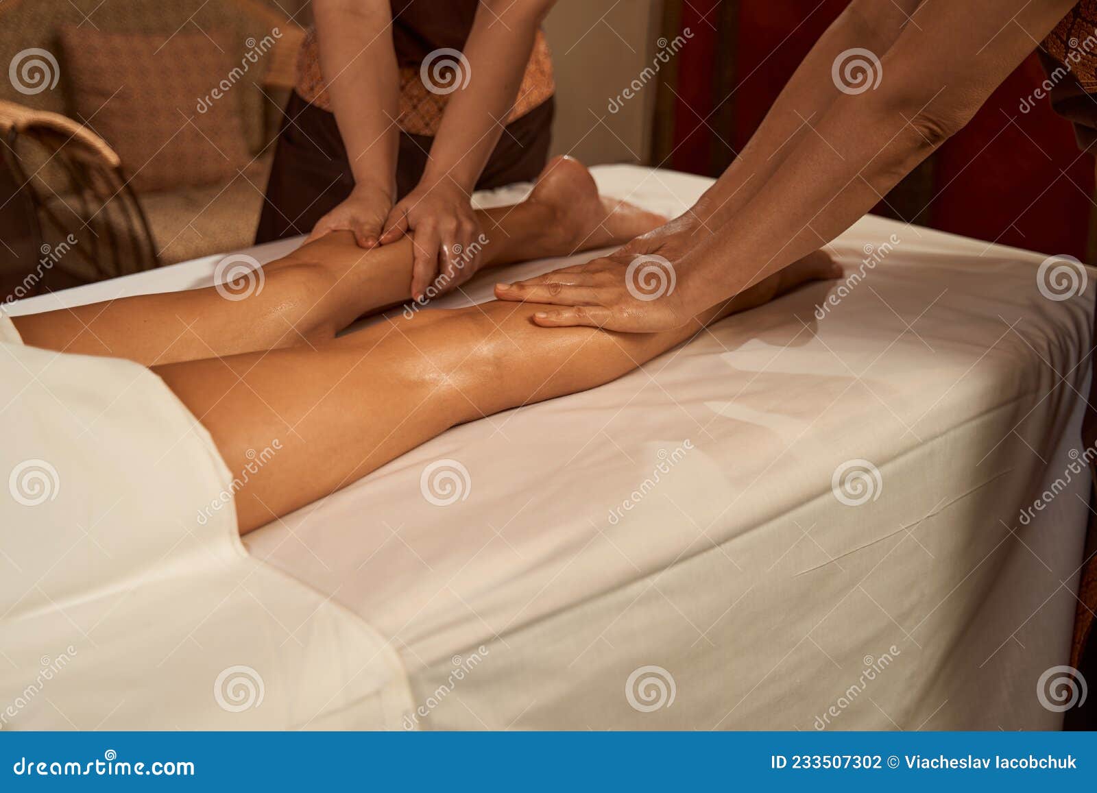 Two Masseuses Employing Four-hand Thai Massage Stock Photo of practitioner, press: 233507302