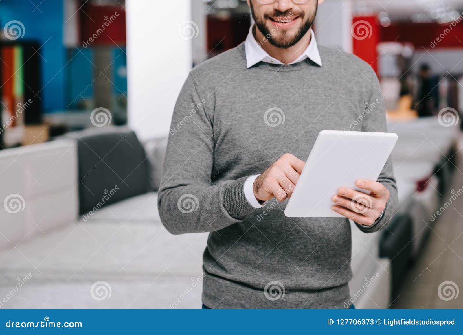 cropped shot of man using digital tablet in furniture store