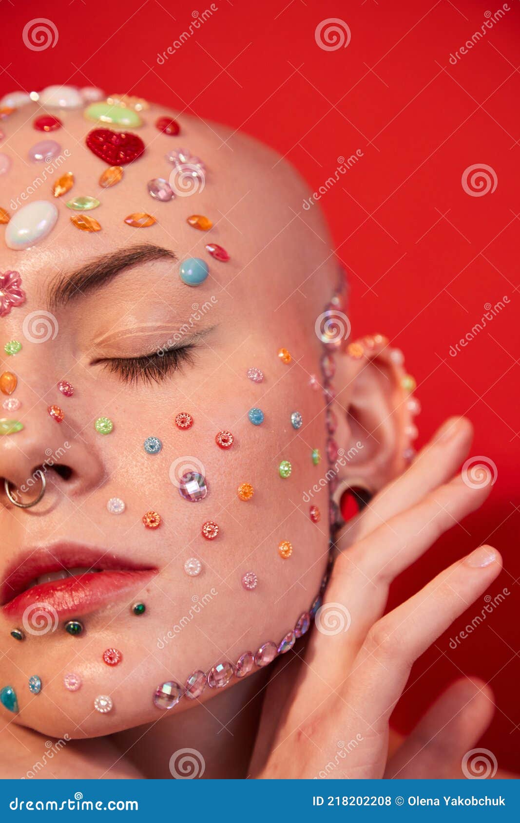 mannish female with piercing and decor at her face posing with eyes closed