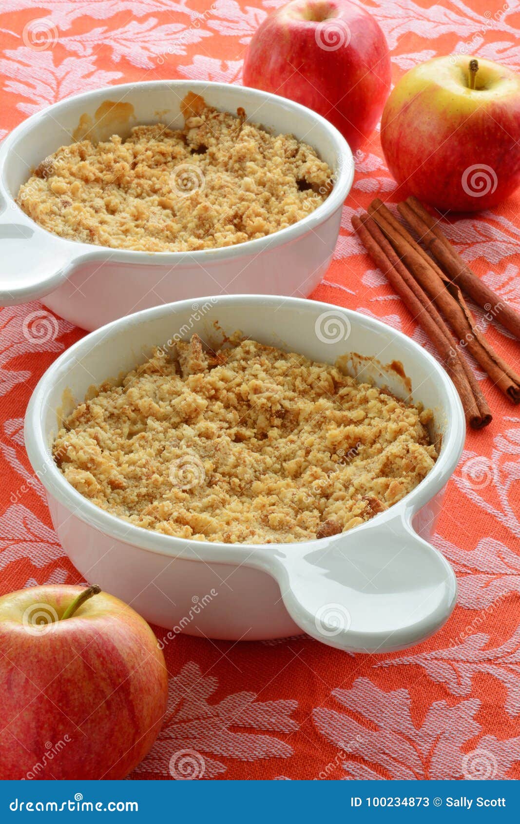 Crumble Яблока. Традиционное домашнее сделанное яблоко крошит на оранжевой предпосылке лист дуба в вертикальном формате Еда комфорта на падение