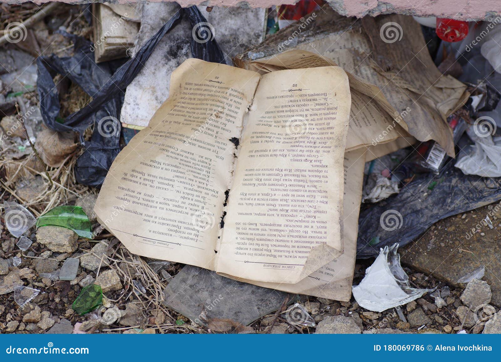 Crumpled Dirty Torn Book Lies On The Ground Among Various Rubbish Stock