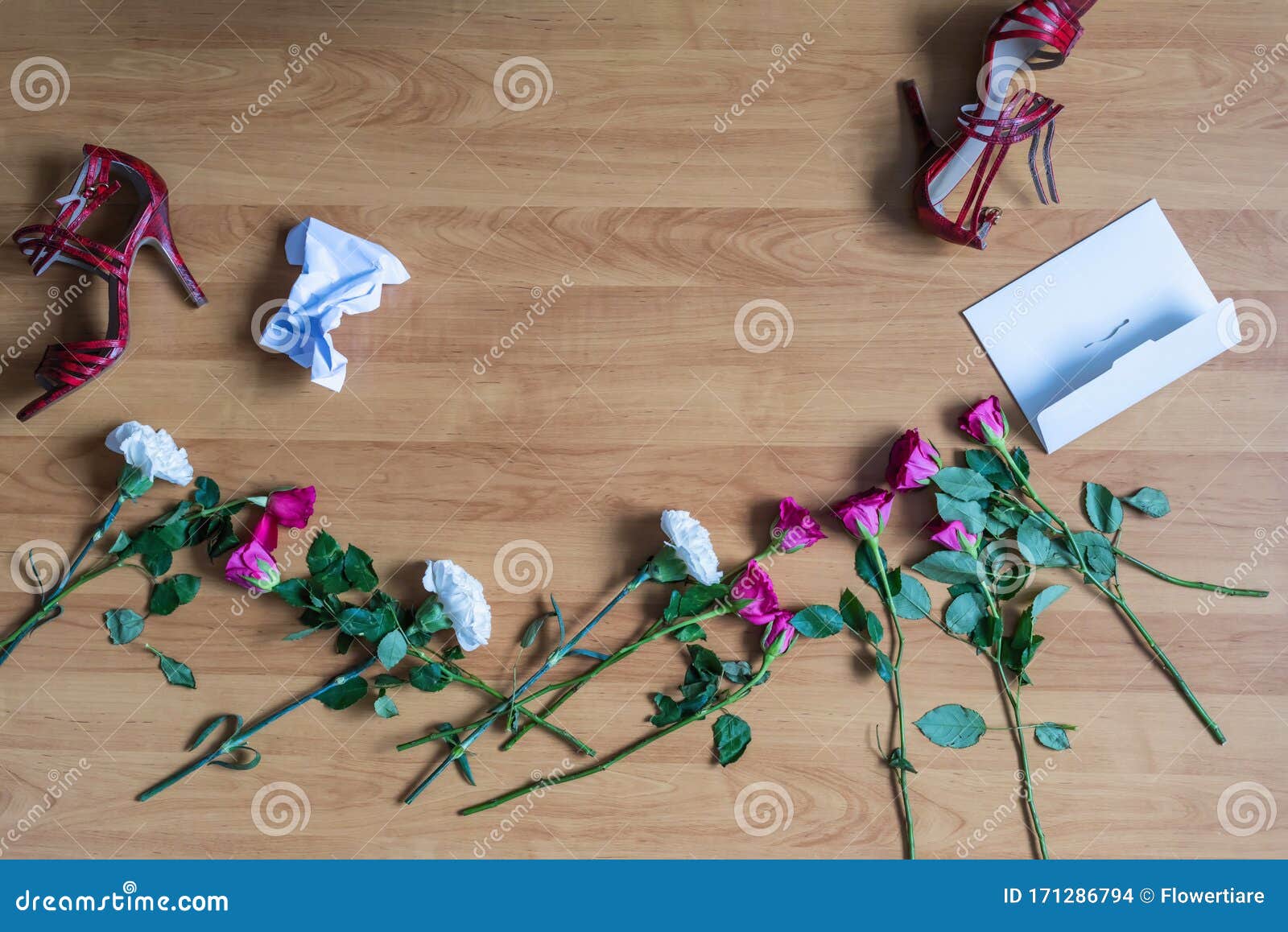 crumpled paper of letter and scattered flowerson the floor. broken relationships in bad valentine`s day. concept.