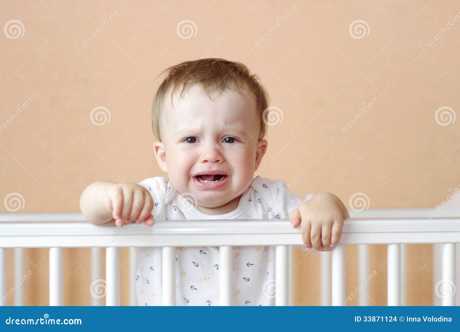 Crying baby in white bed stock photo. Image of whimsical 33871124
