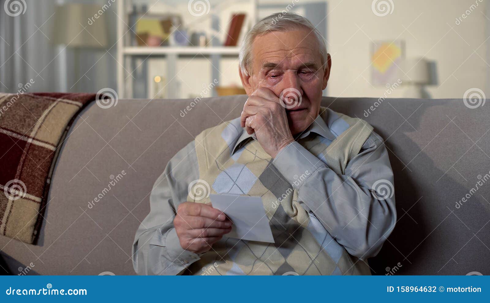 crying elderly man looking at photo, remembering old lost friend, memories