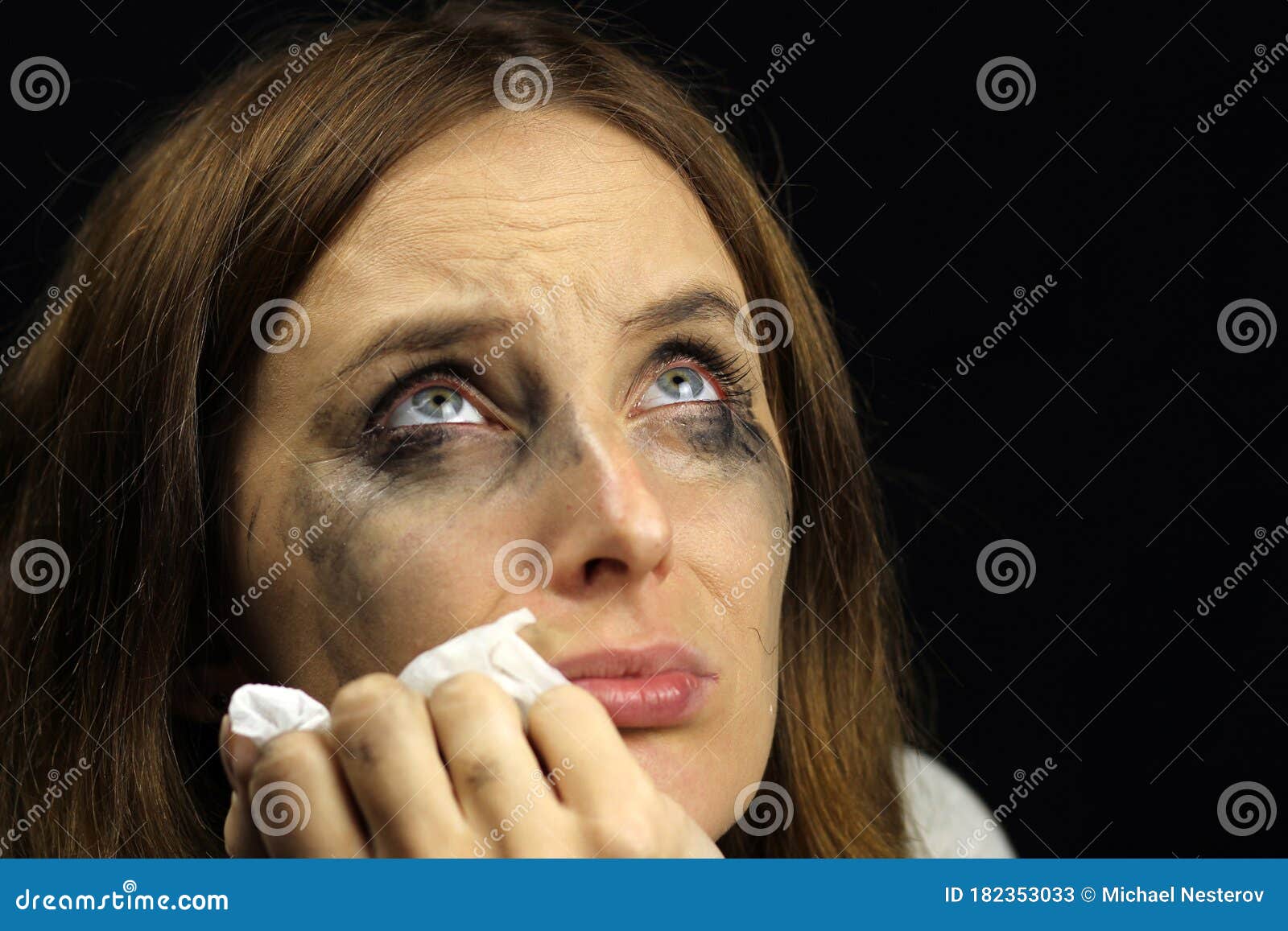 Crying Girl with Smeared Mascara on a Black Background Stock Image
